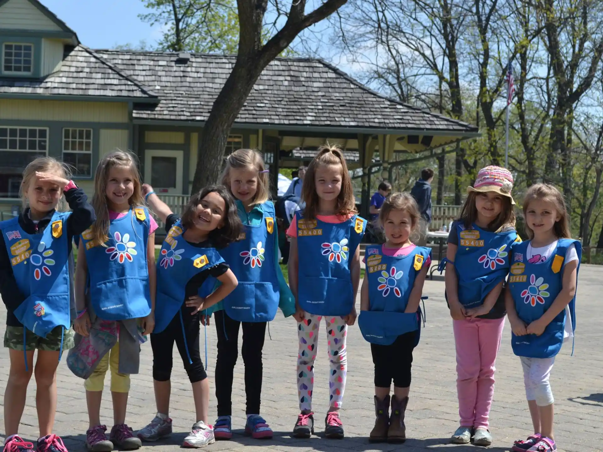 a group of girls in matching blue shirts standing in front of a house