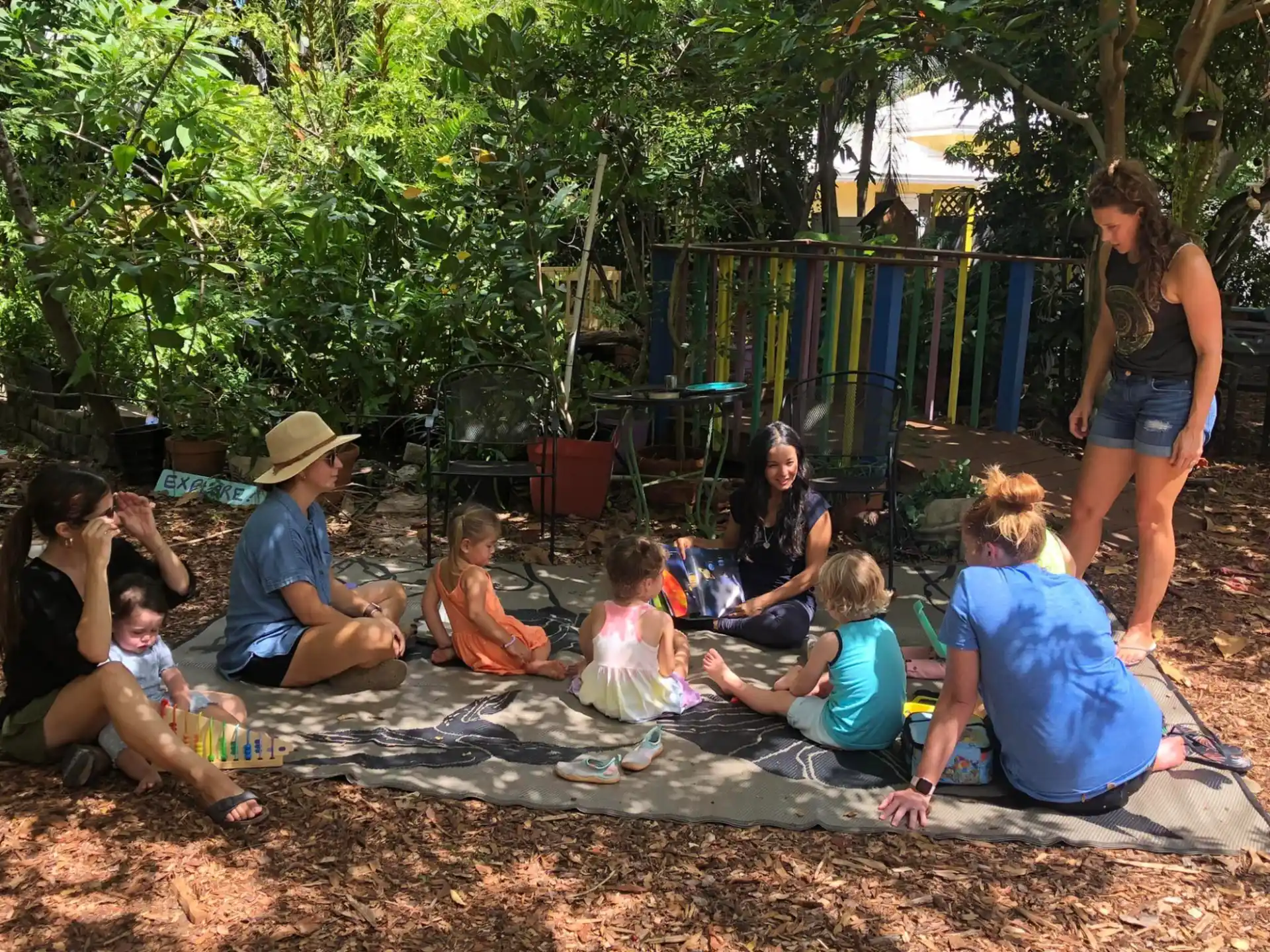a group of people sitting on a blanket in a playground