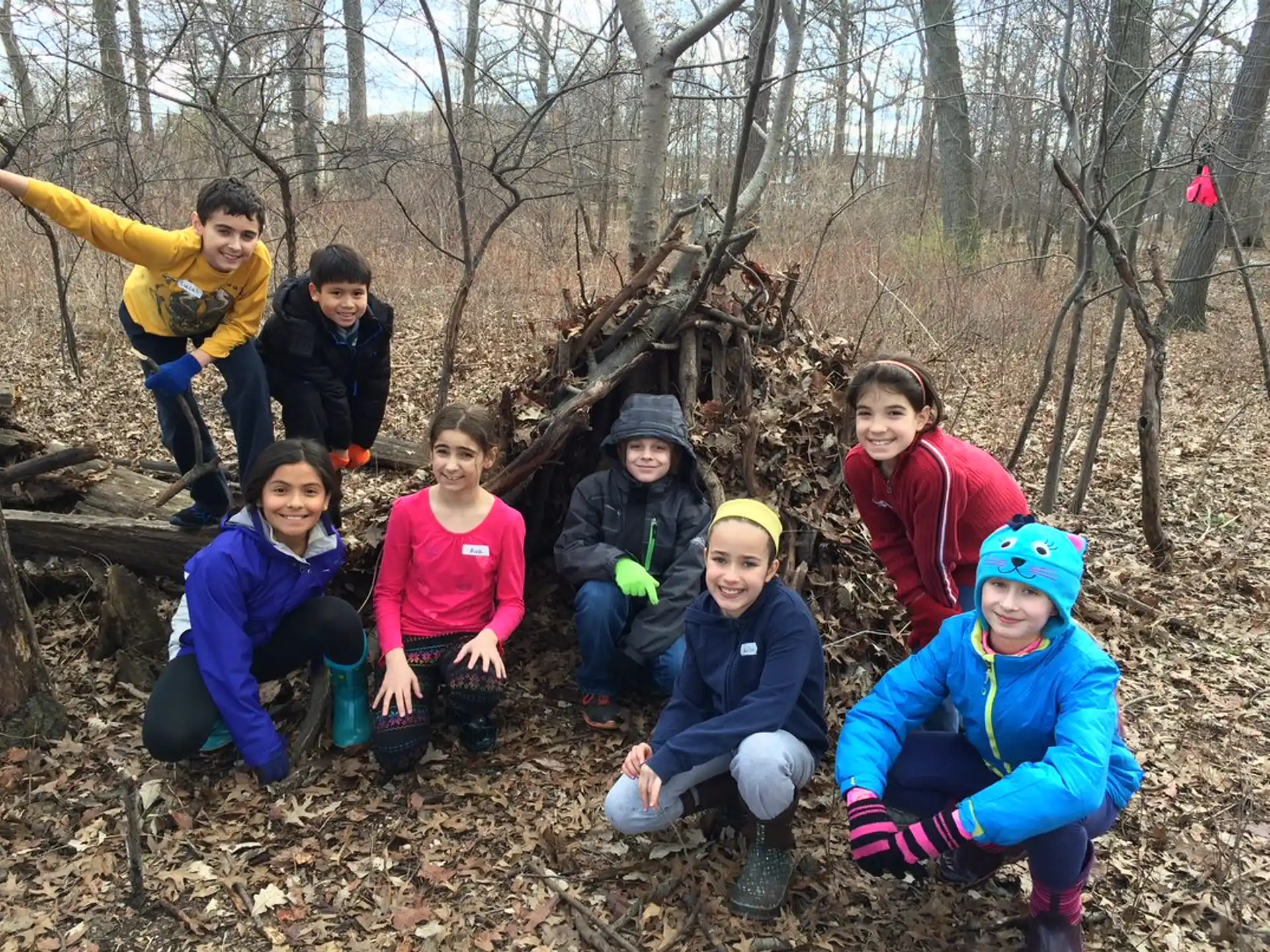 a group of children posing for a photo in the woods