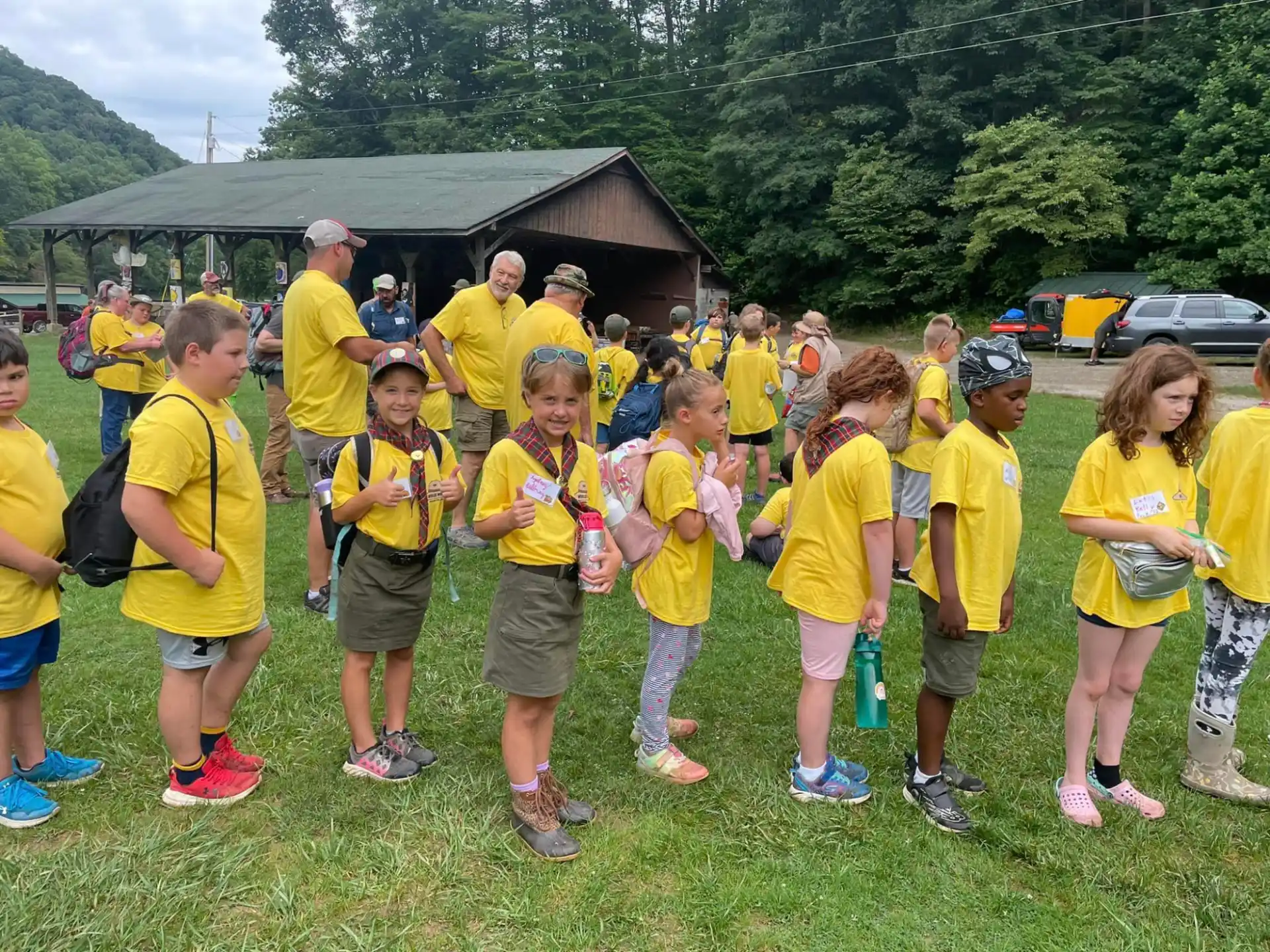 a group of children in yellow t-shirts standing in a grassy field