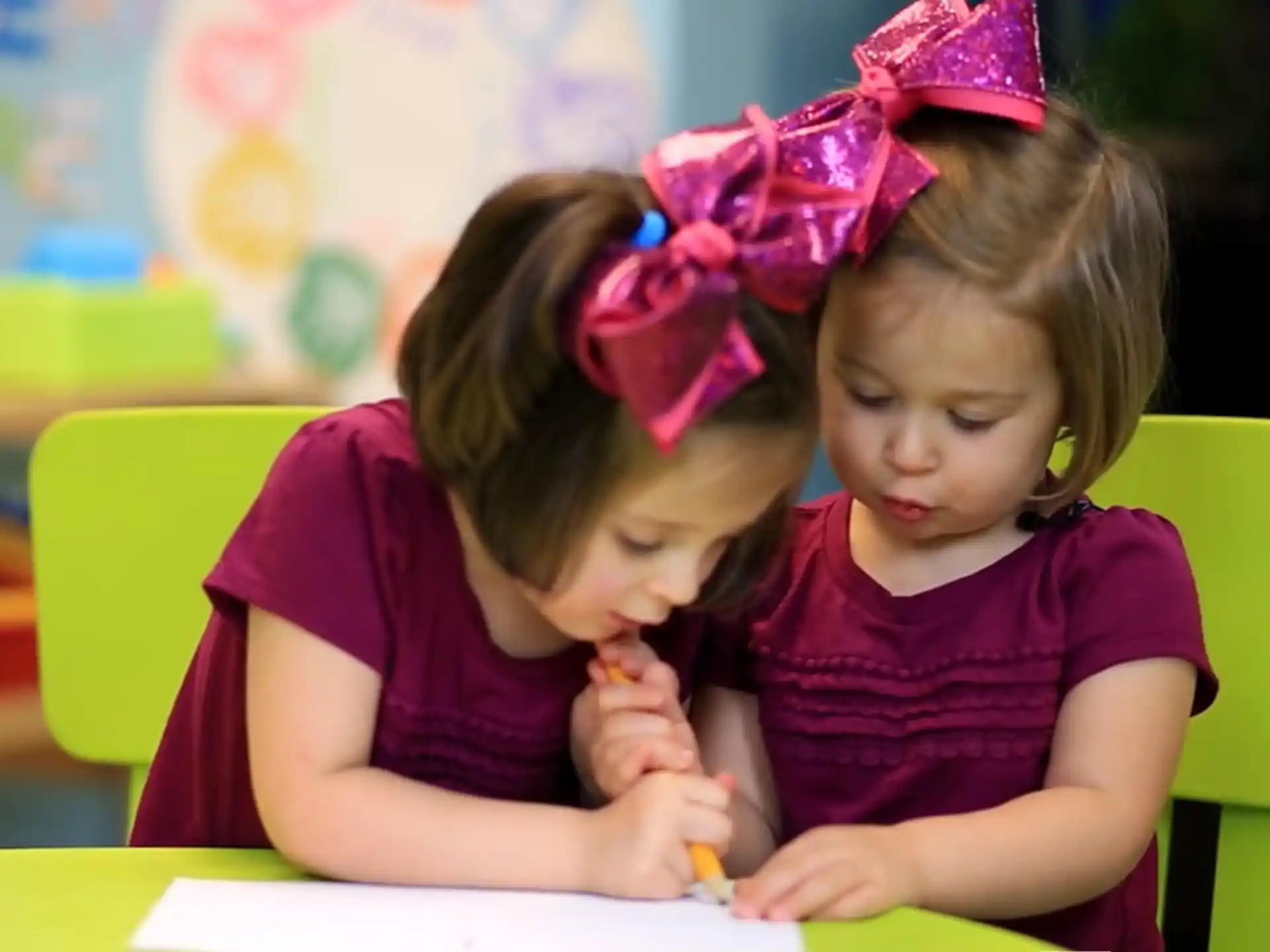 a couple of young girls sitting at a table