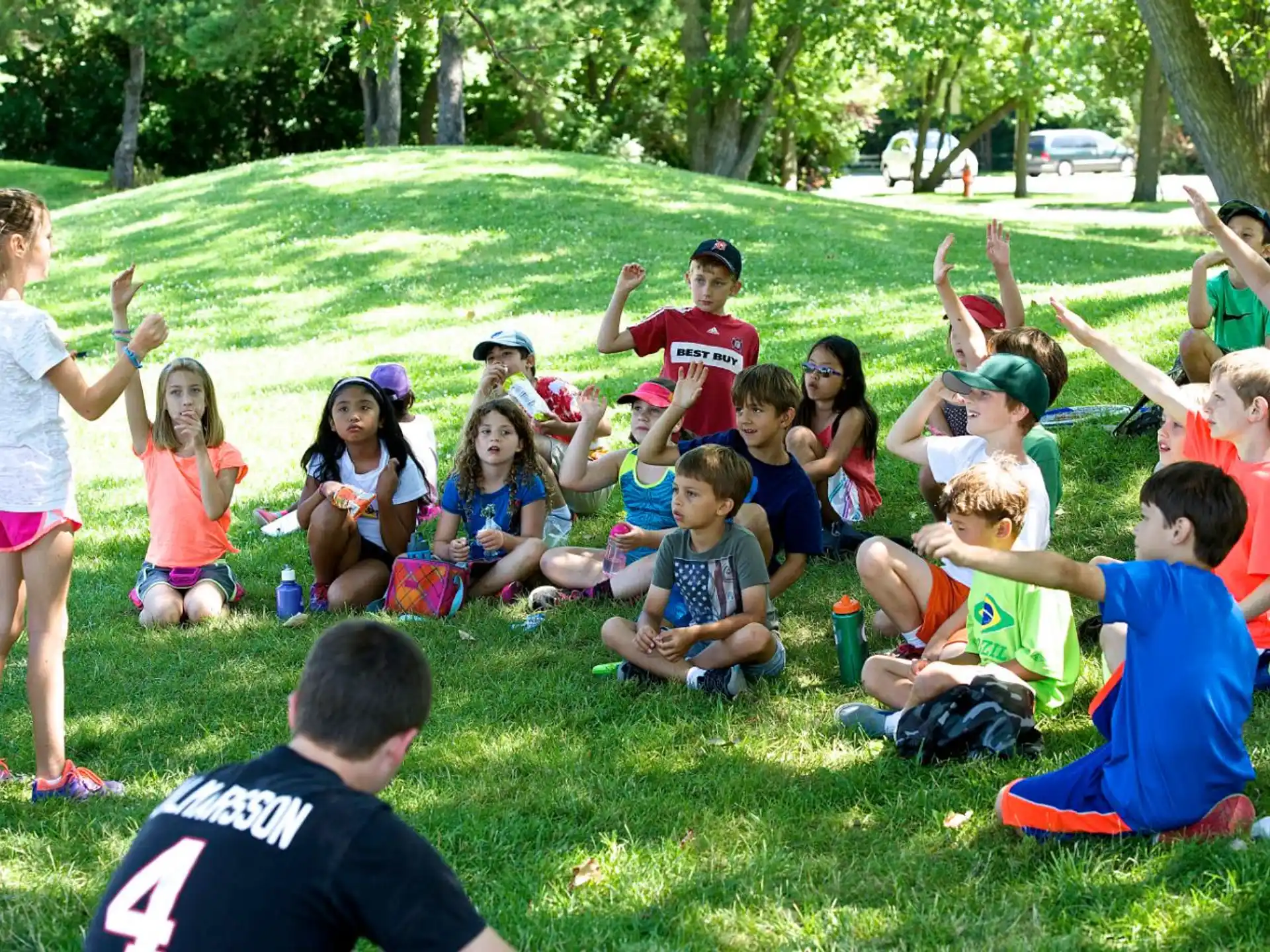 a group of children sitting on the grass