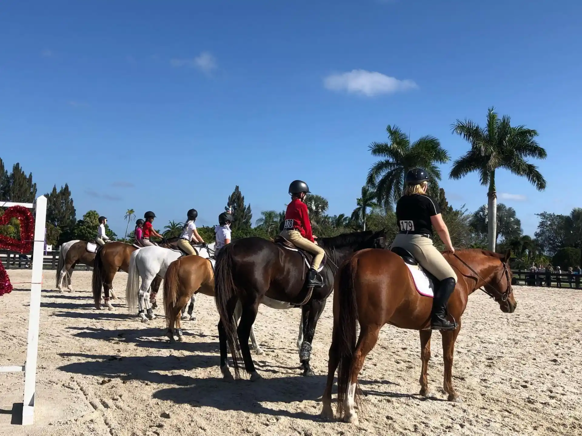 people riding horses on a dirt road