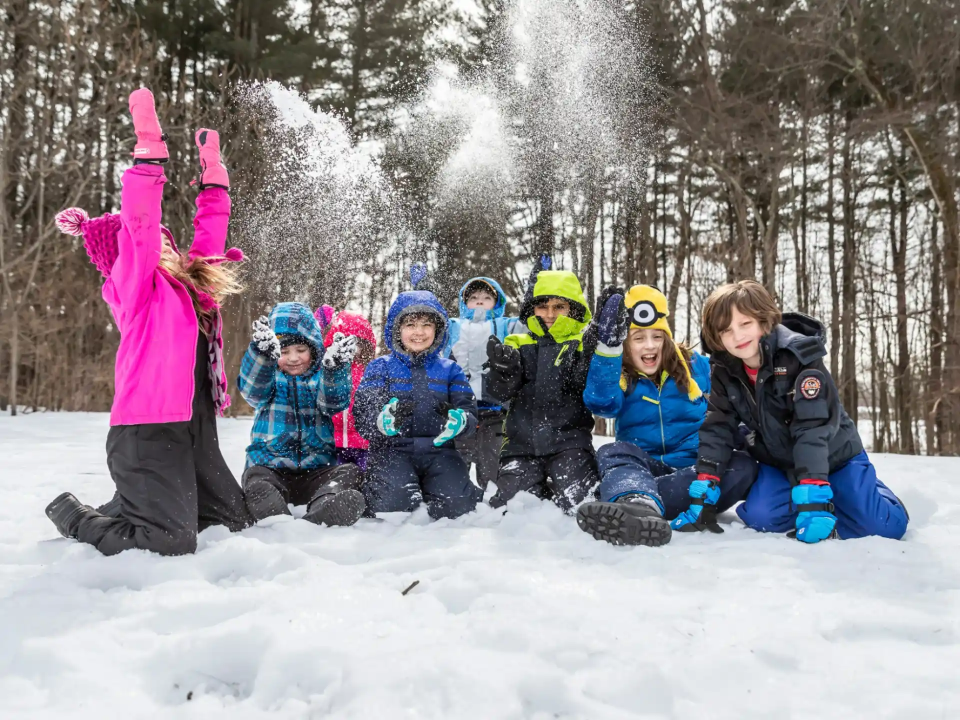 a group of kids sitting in the snow