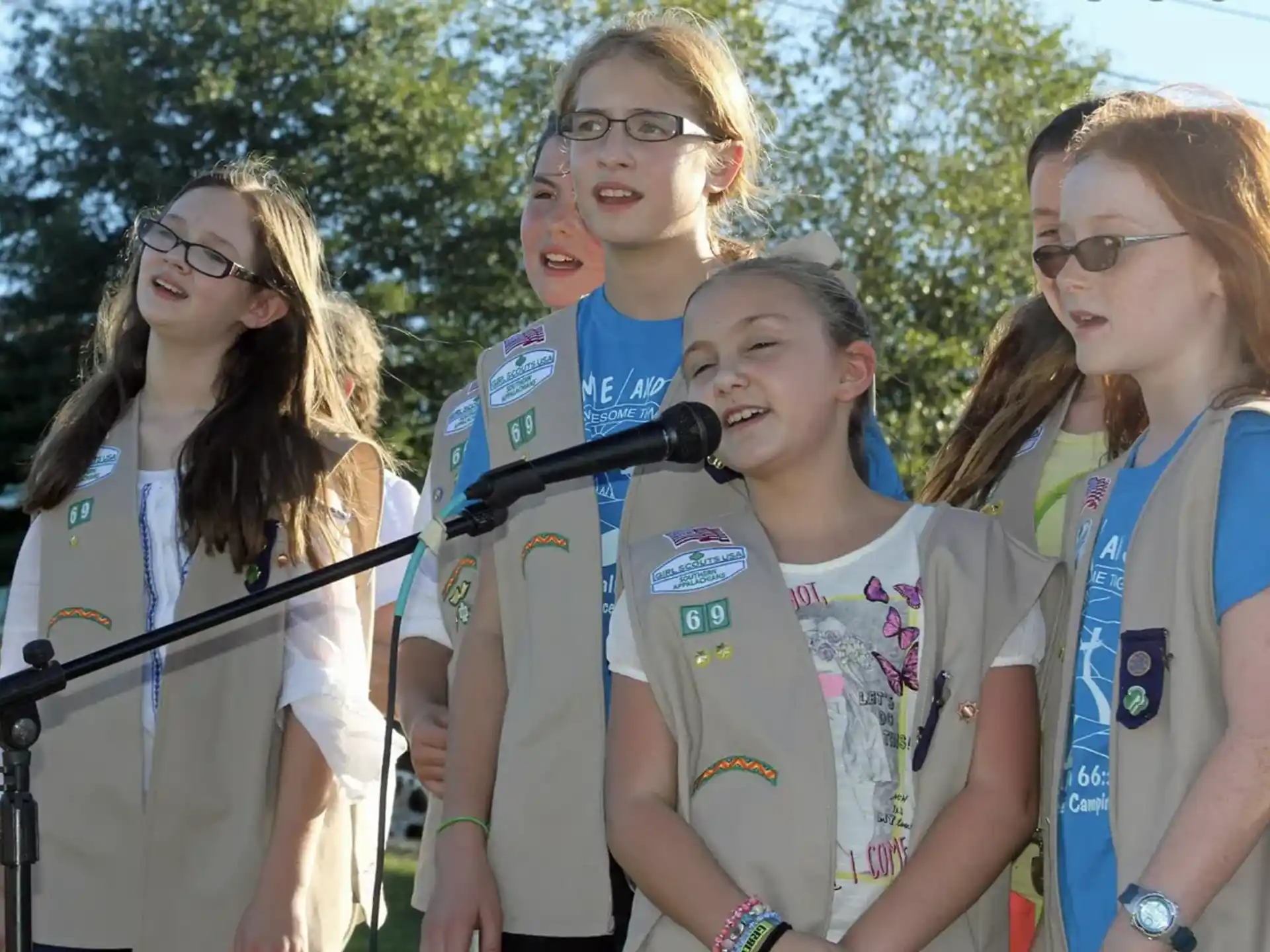 a group of girls standing in front of a microphone