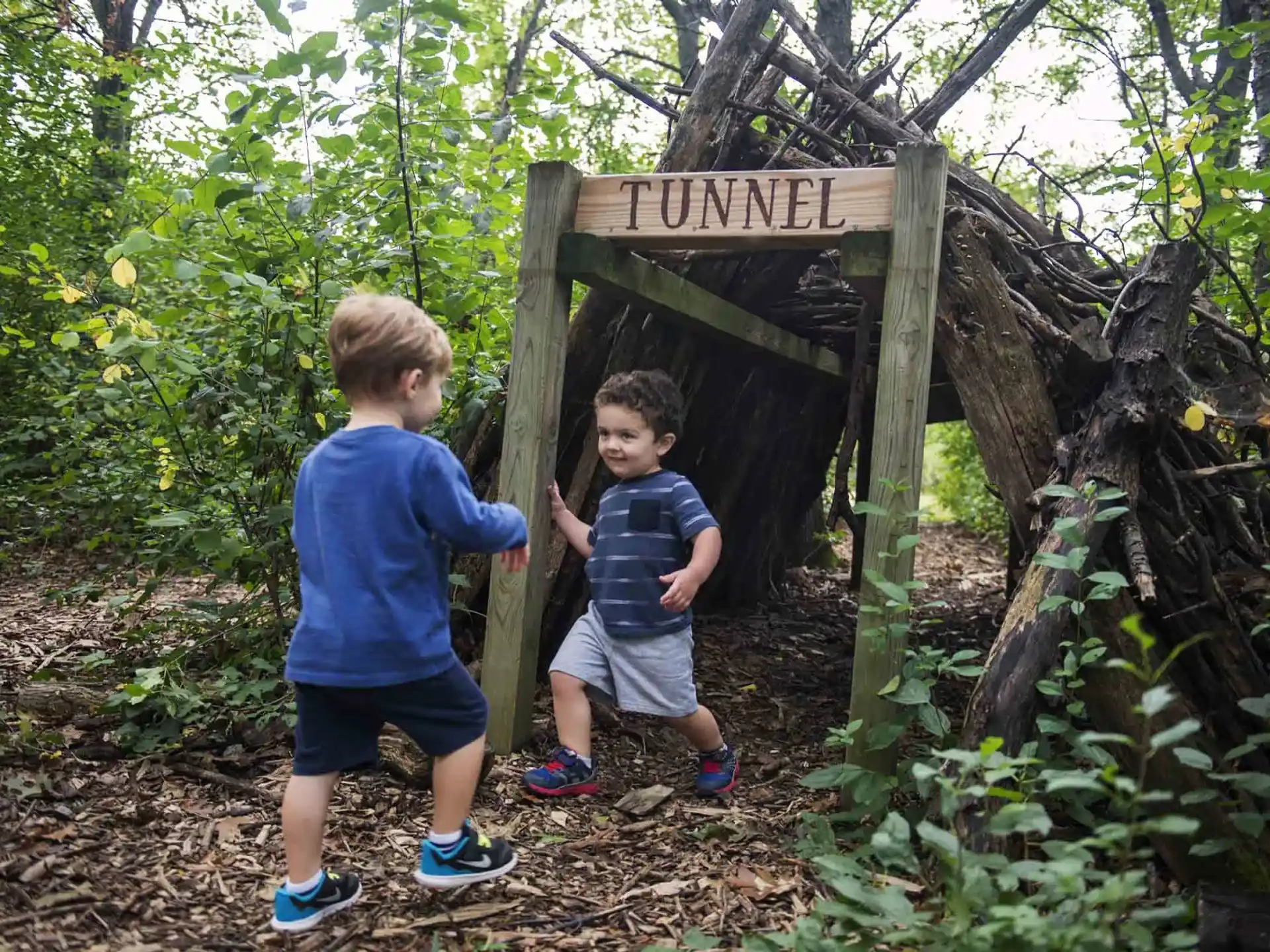 two boys standing next to a sign