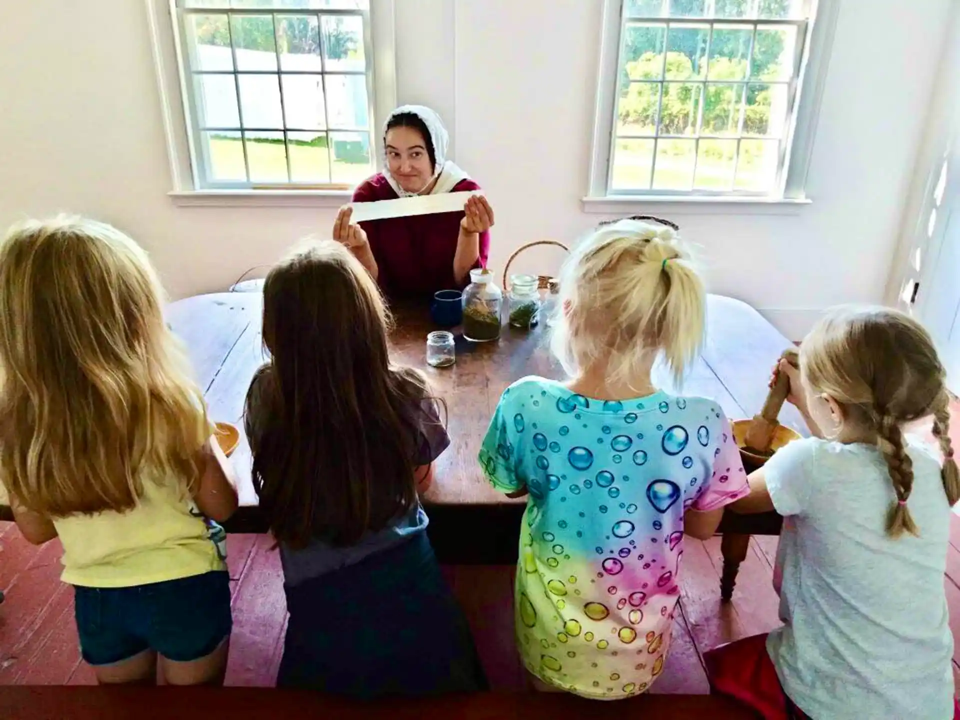 a group of children sitting around a table