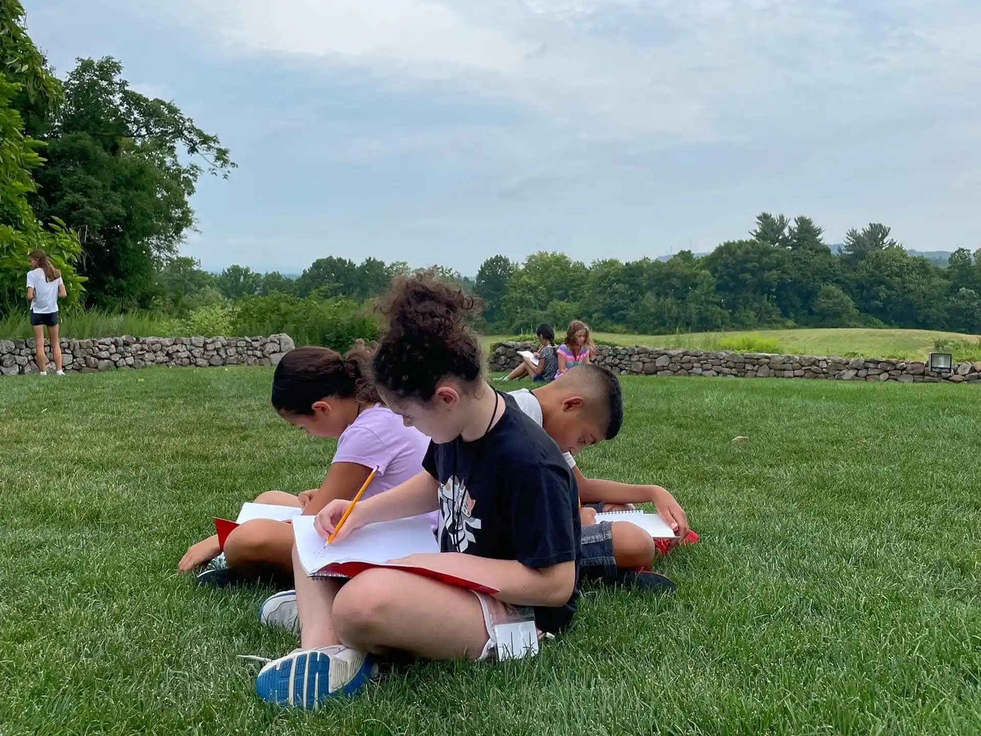 a group of people sitting on the grass
