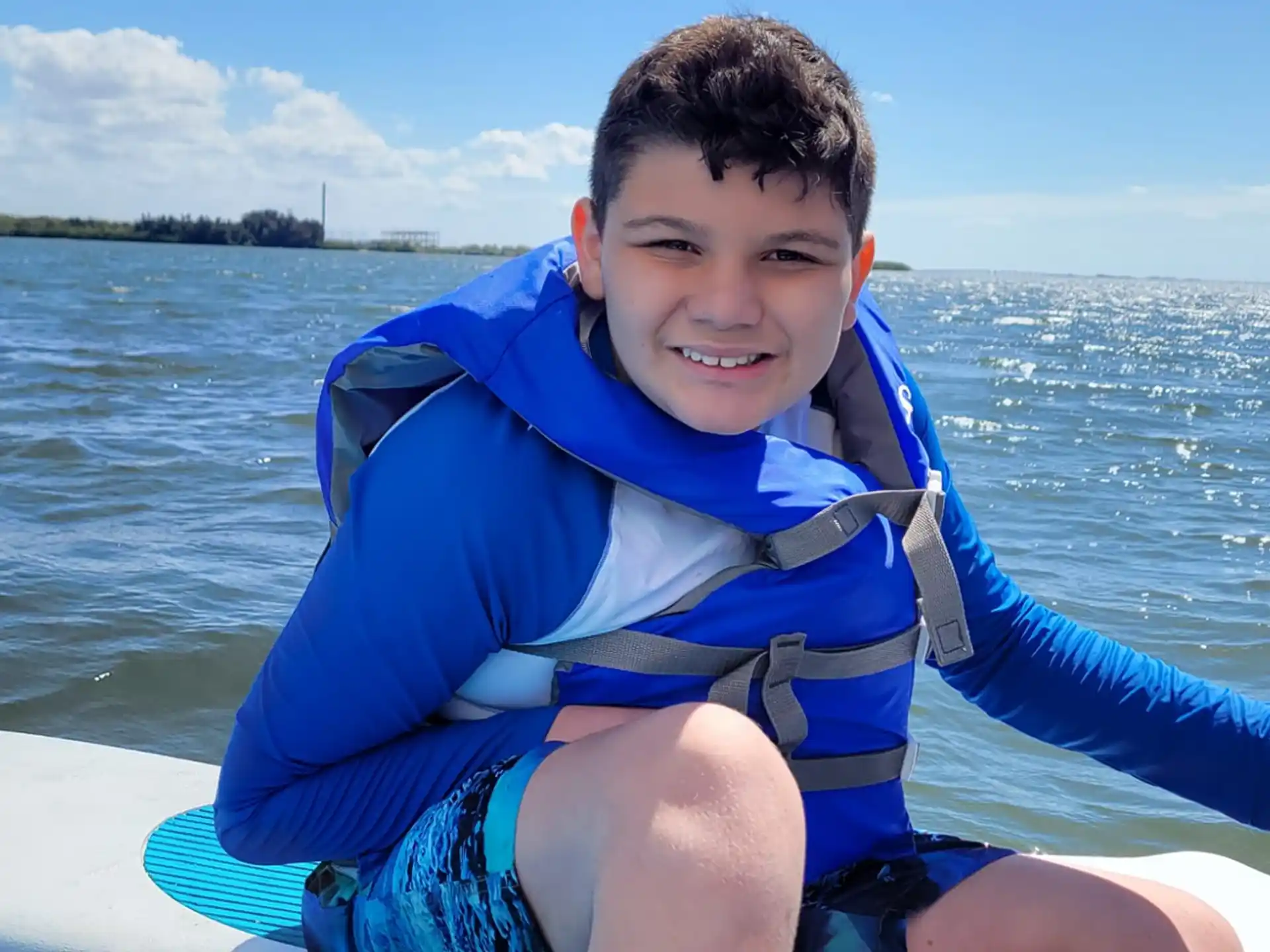 a boy in a life jacket on a boat