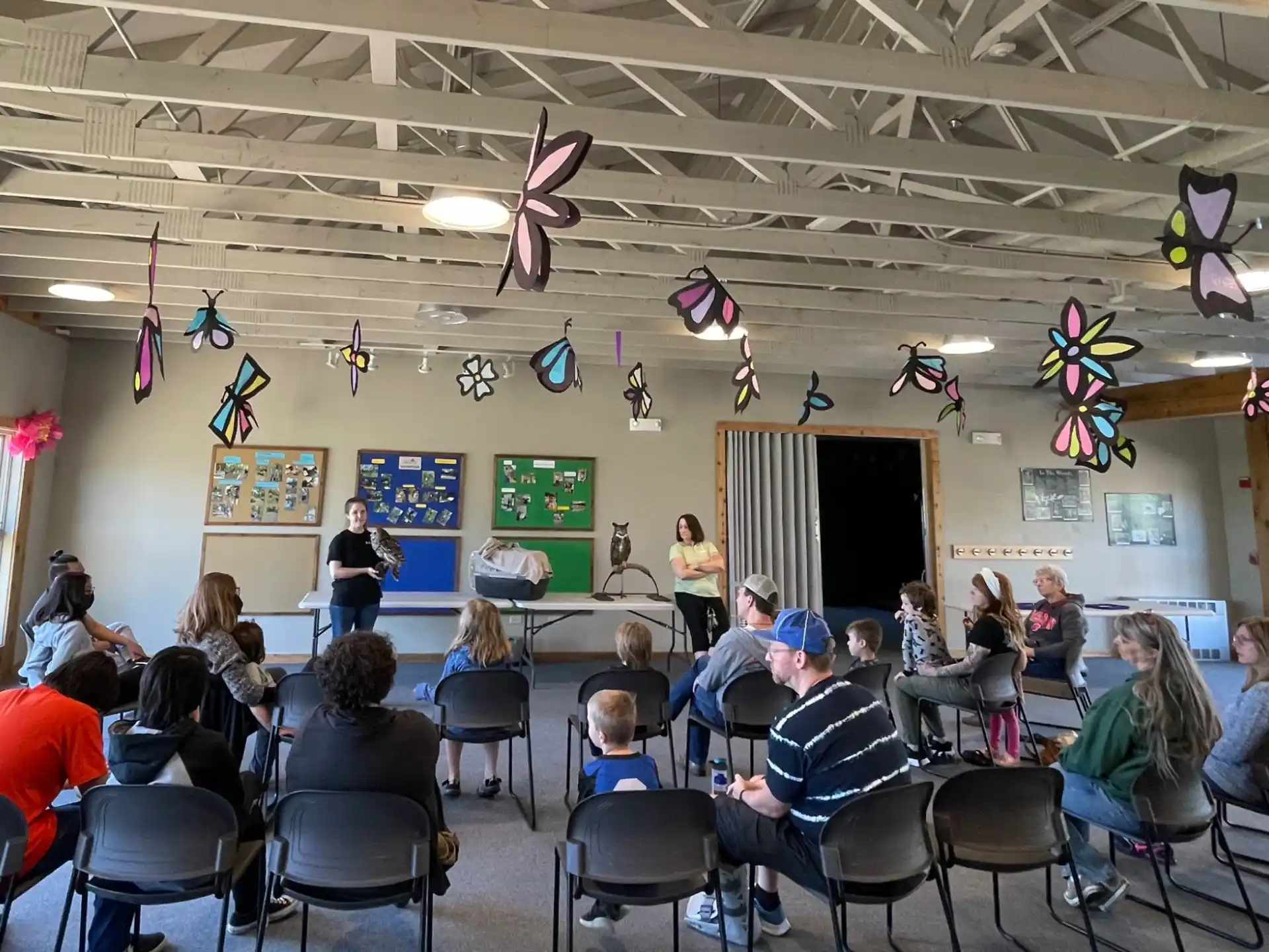 a group of people sitting in a room with kites from the ceiling