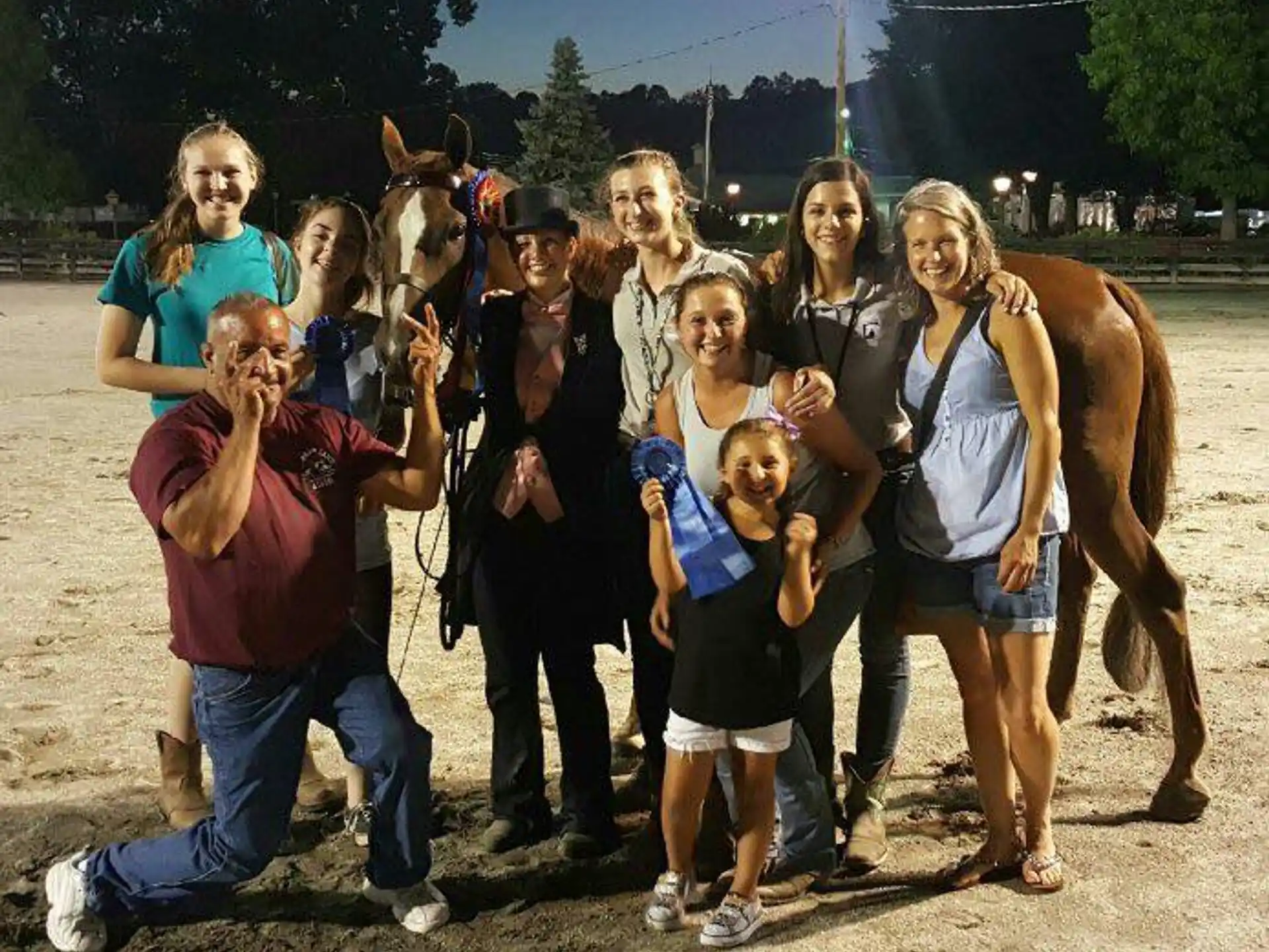 a group of people posing for a photo with a horse