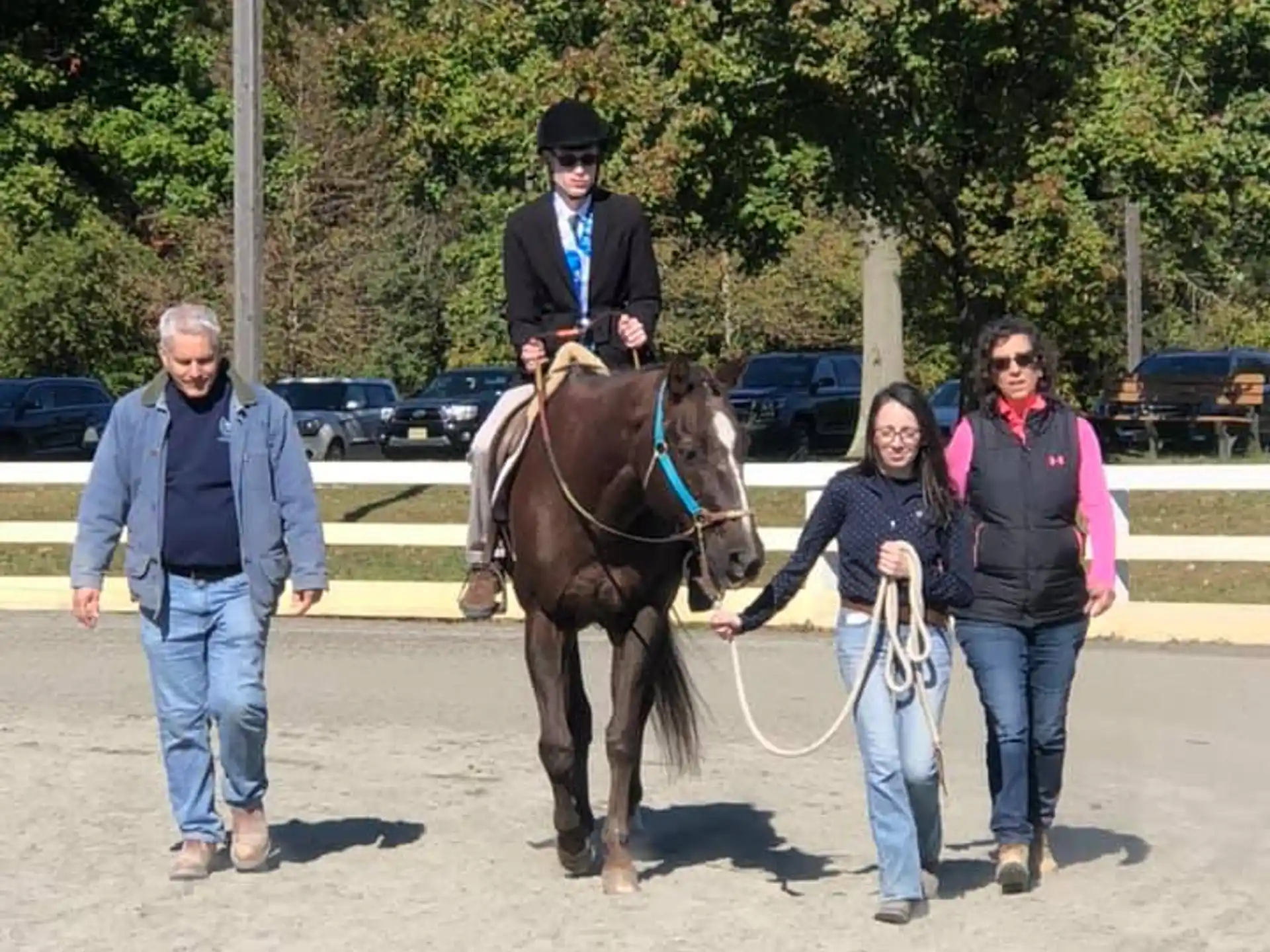 a man riding a horse with a woman walking by him