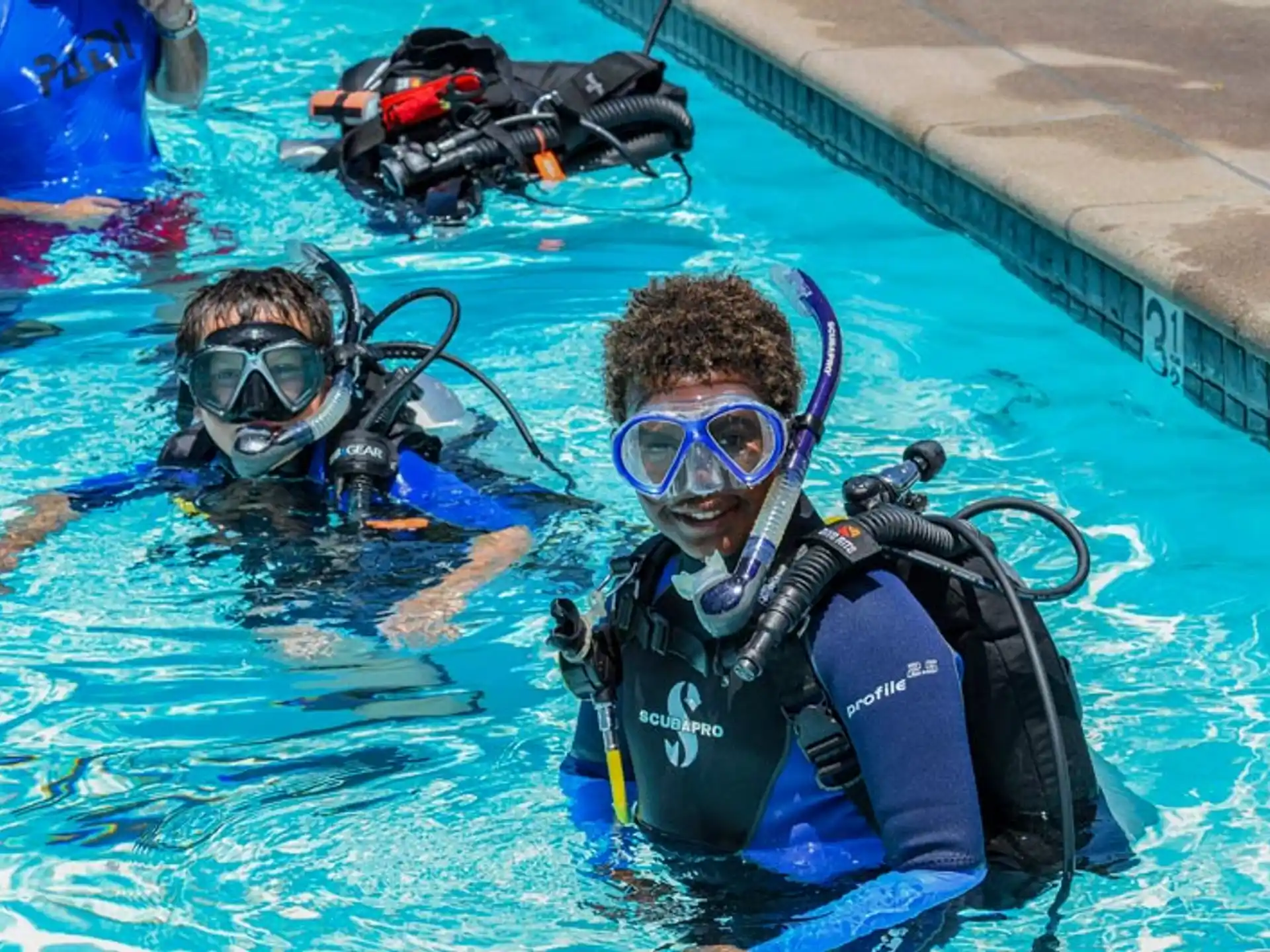 a couple of people in scuba gear in a pool