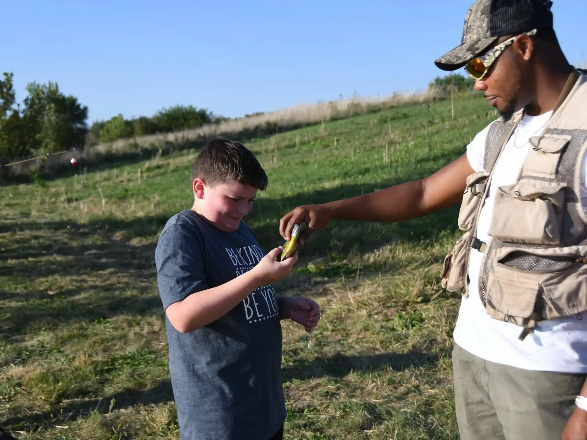 a man and a boy holding a small yellow snake