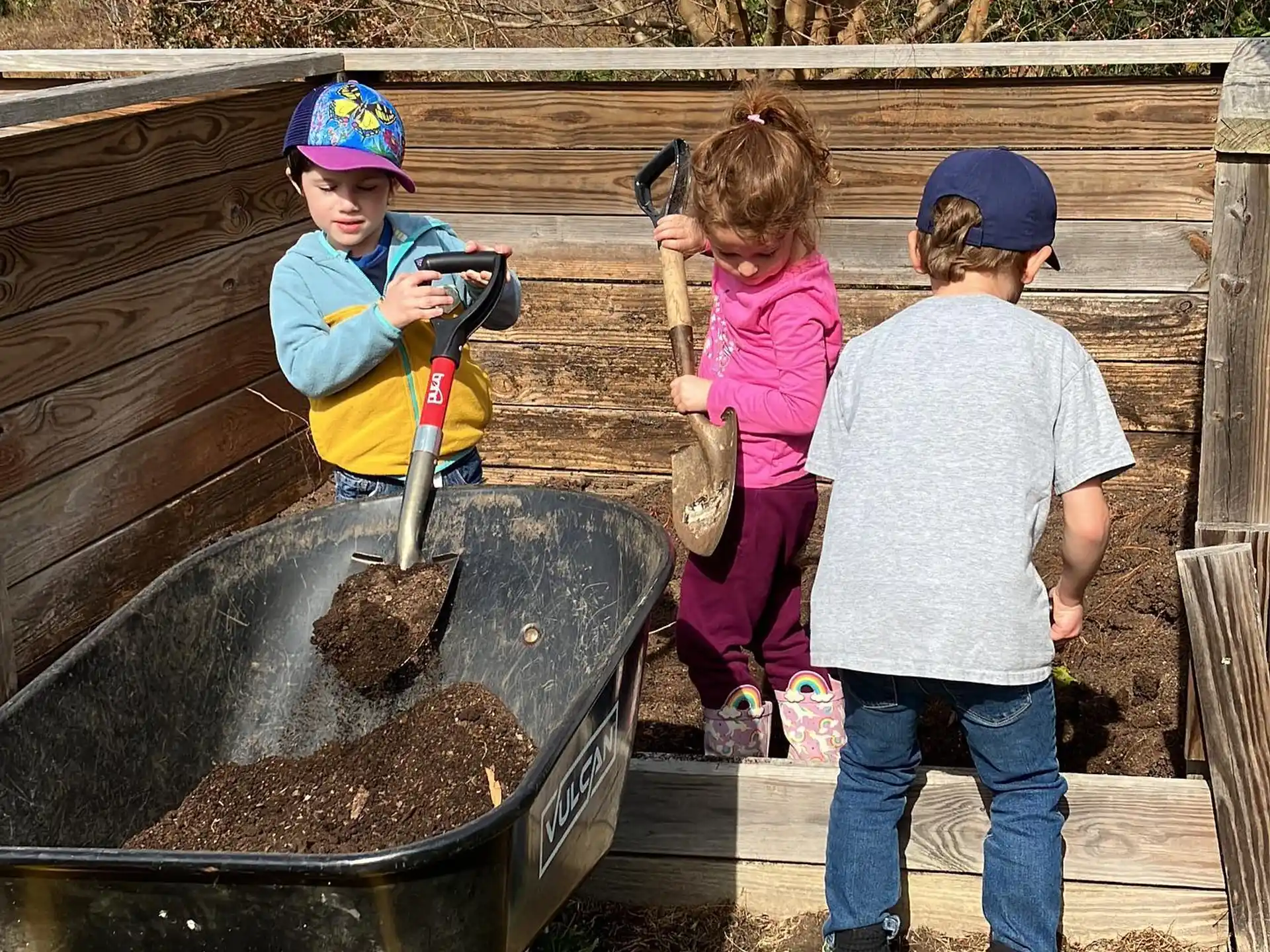 a group of children playing in a wooden wagon