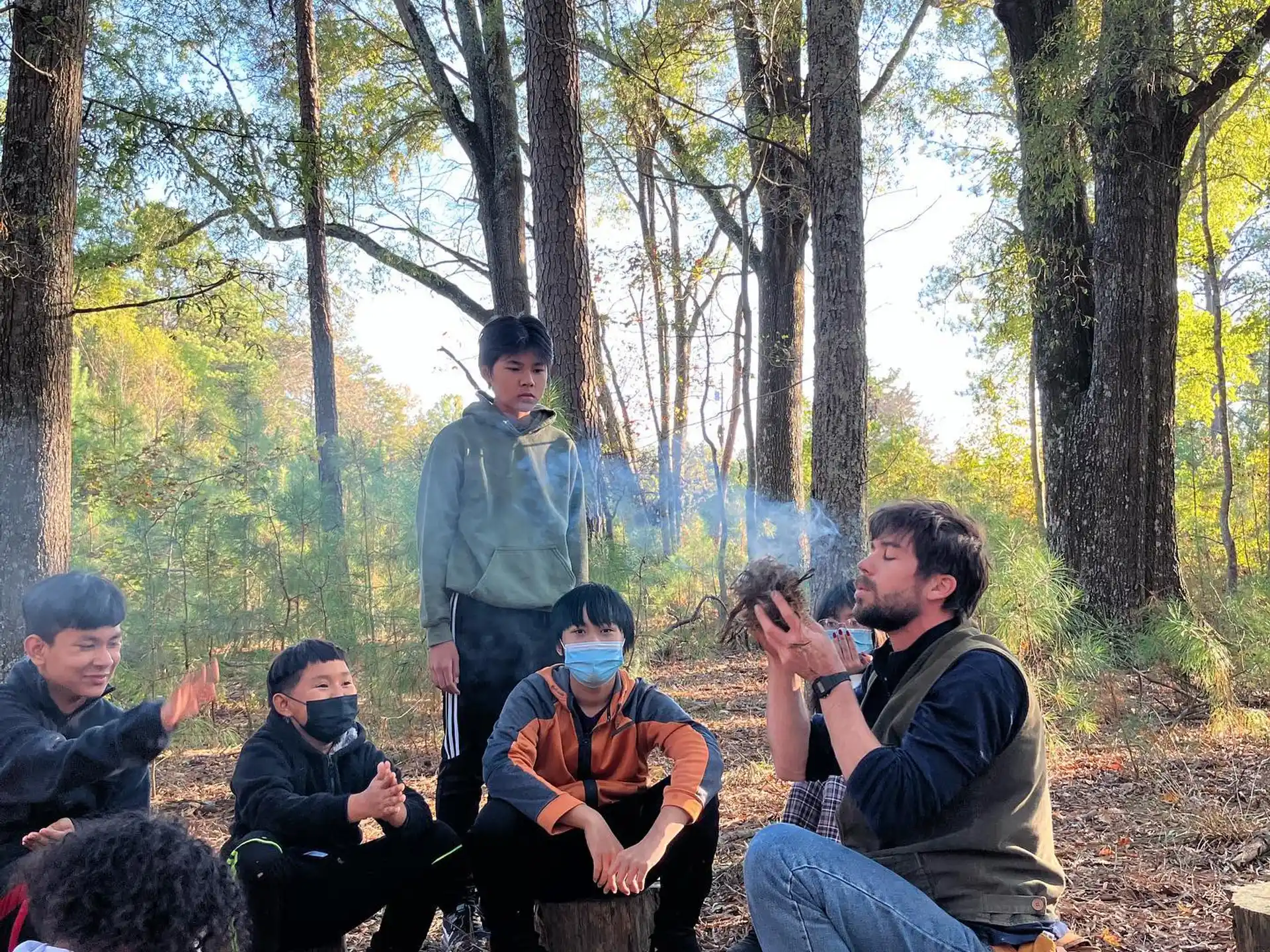 a group of people sitting in the woods