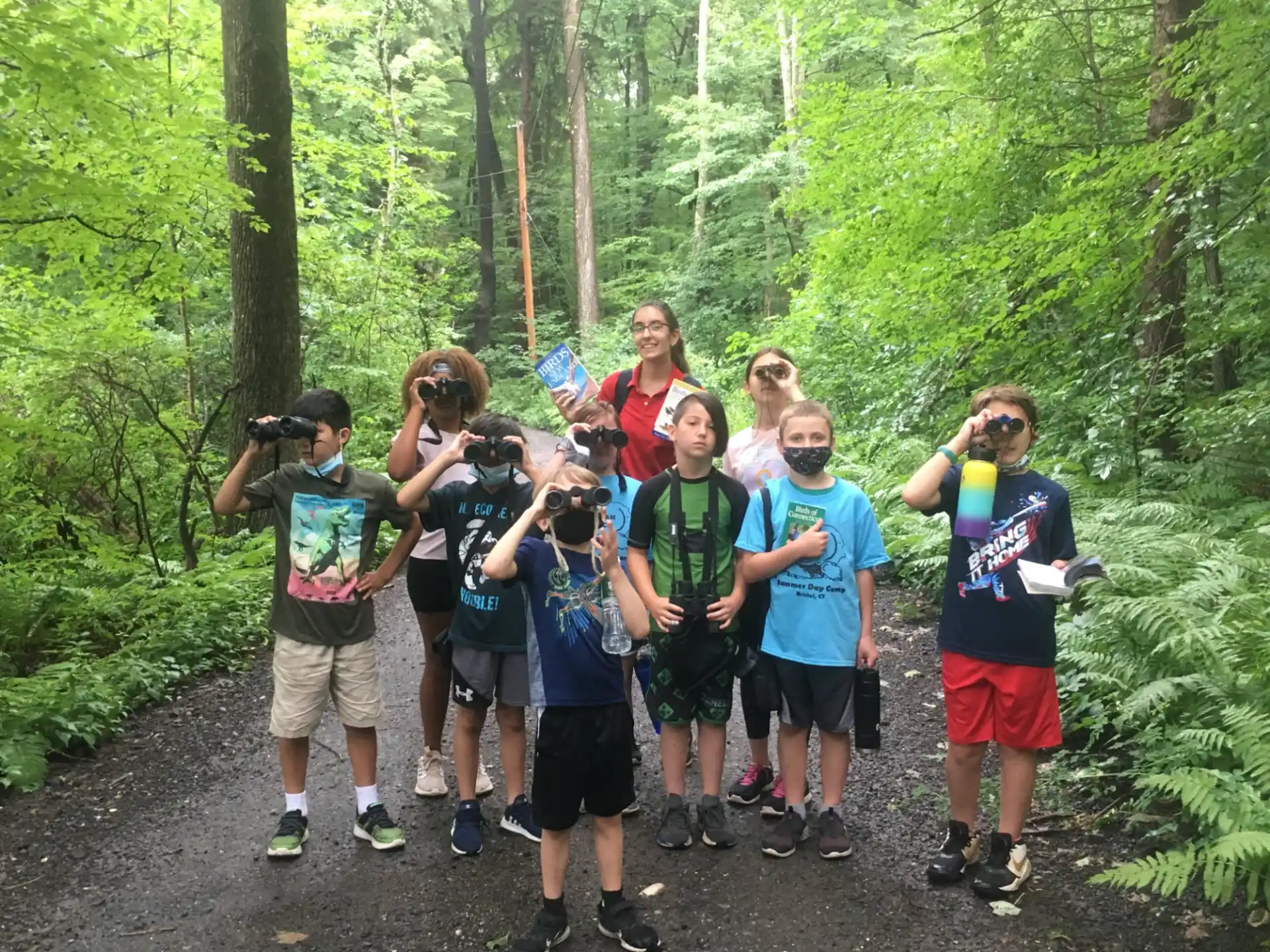a group of people taking pictures in the woods
