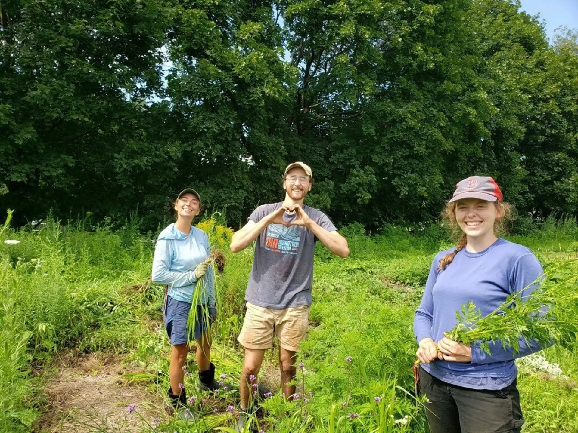 a group of people standing in a field with trees in the background