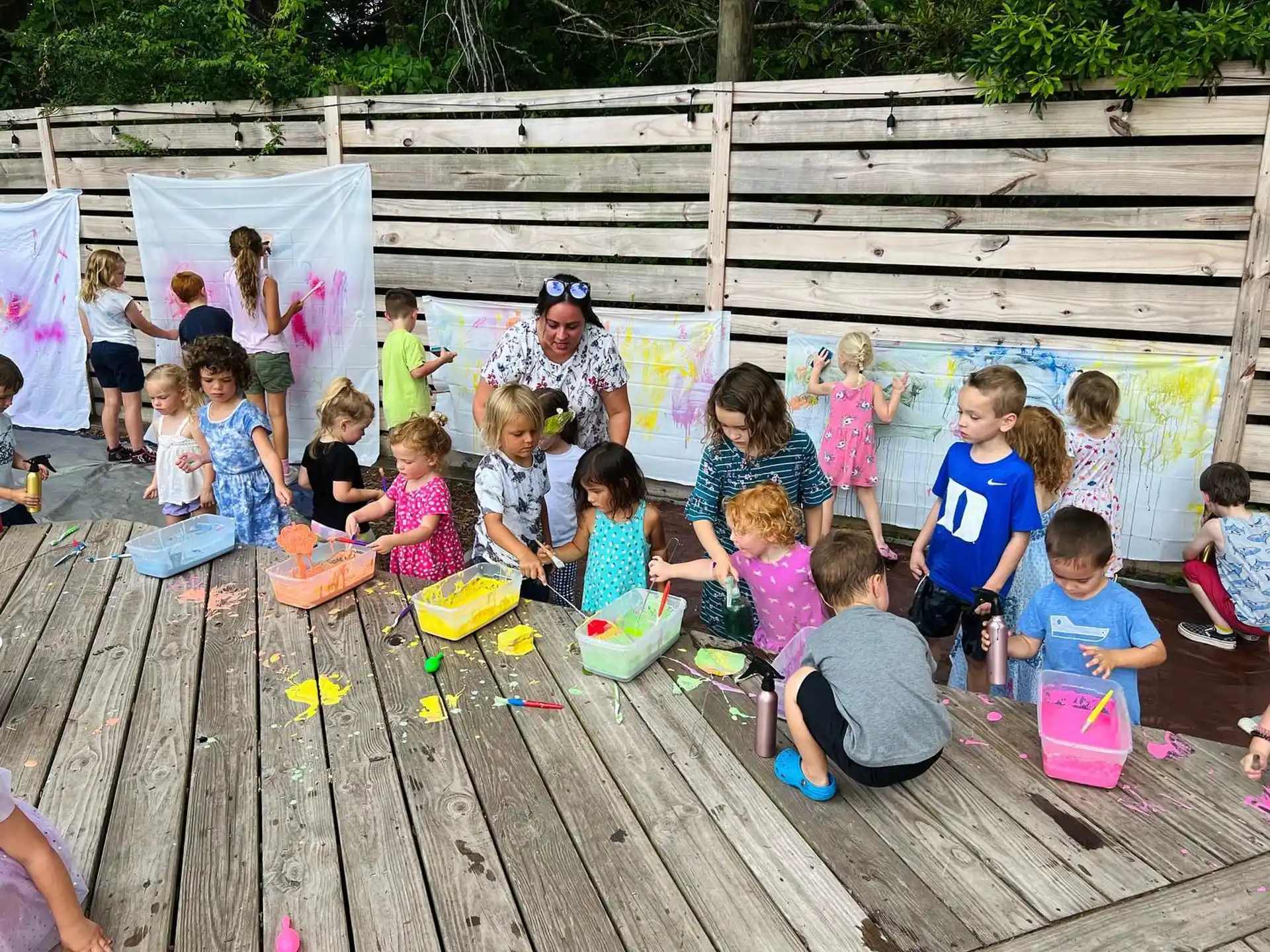 a group of children sitting on a wooden deck