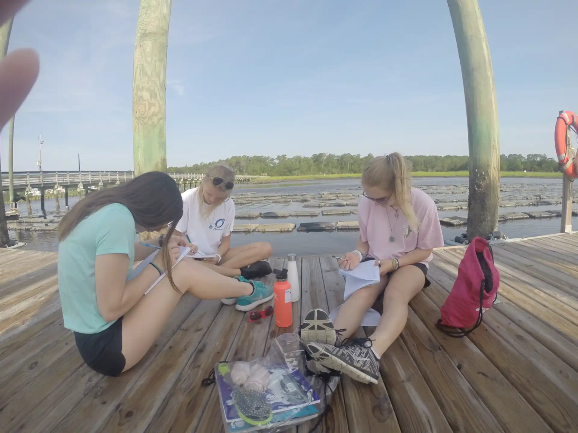 a group of people sitting on a wooden deck