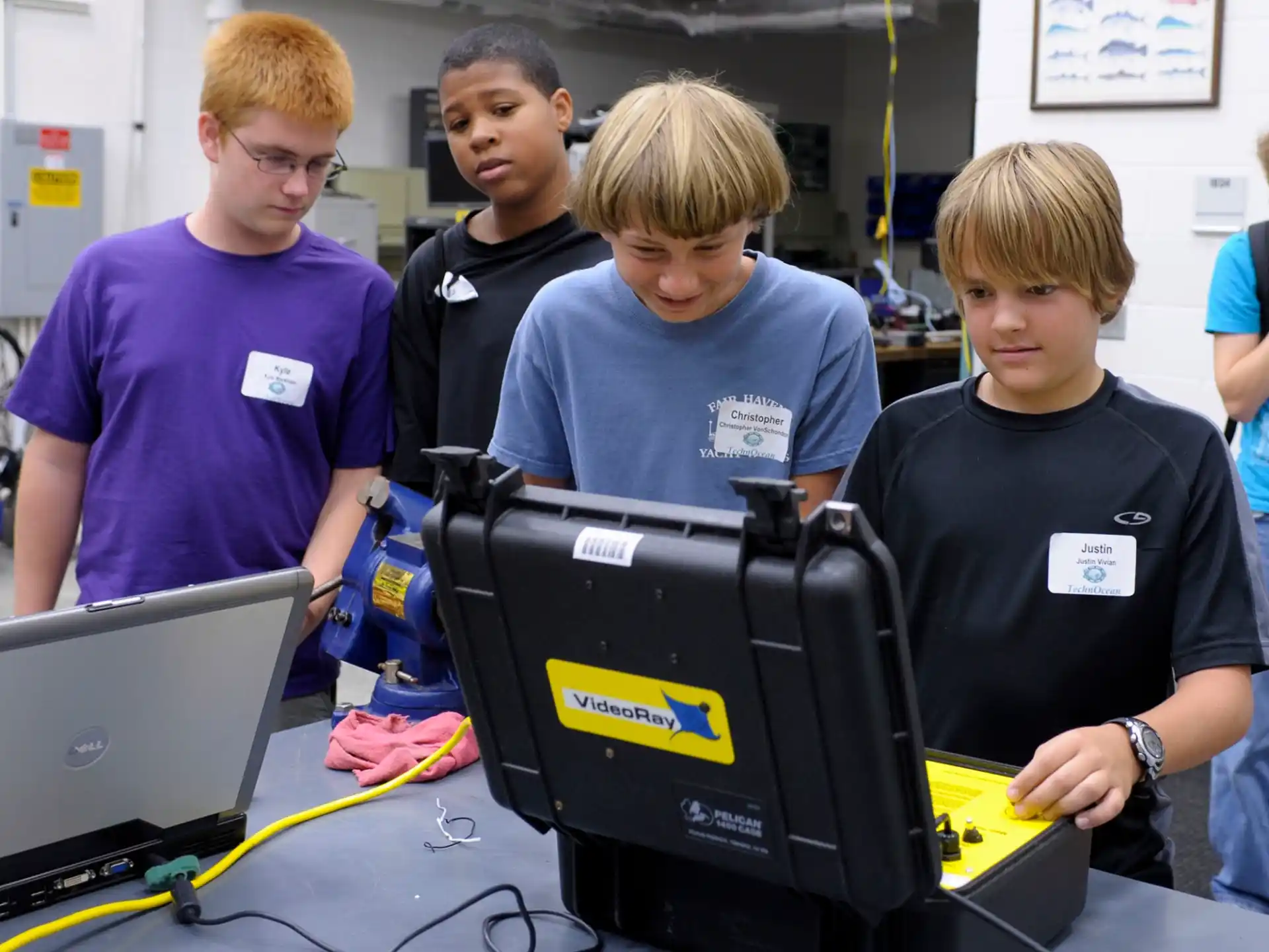 a group of young men looking at a computer