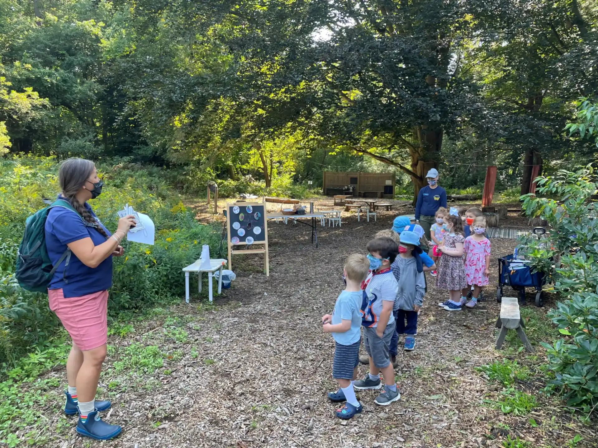 a person and a group of children at a park