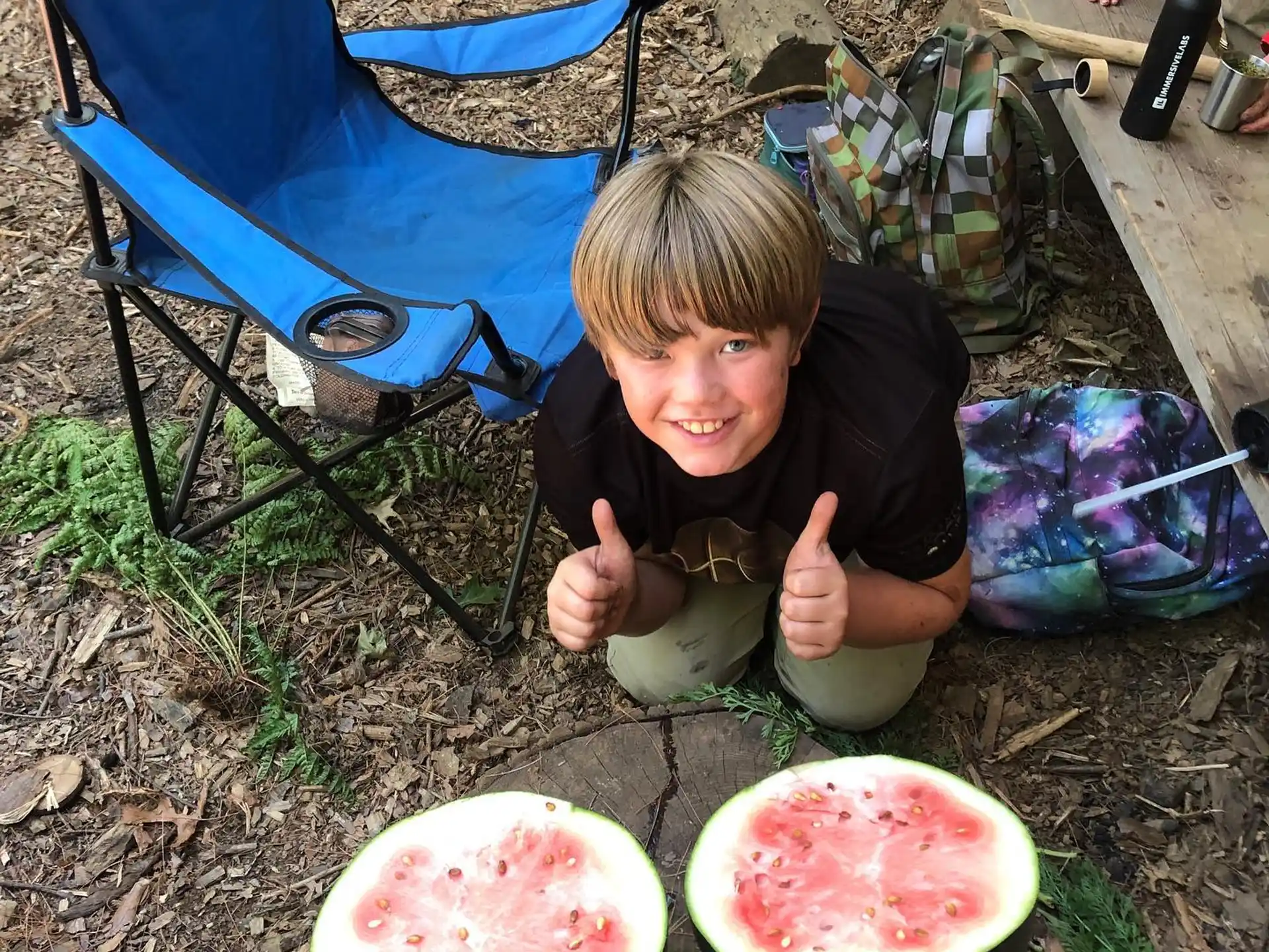 a boy sitting on the ground with a bowl of food