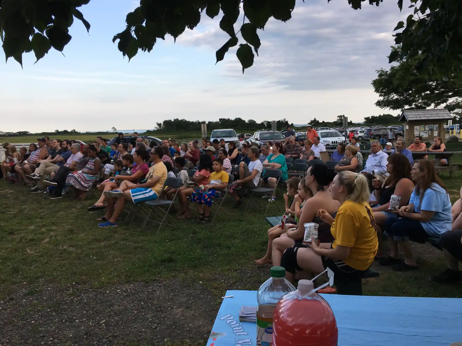 a large group of people sitting on chairs outside