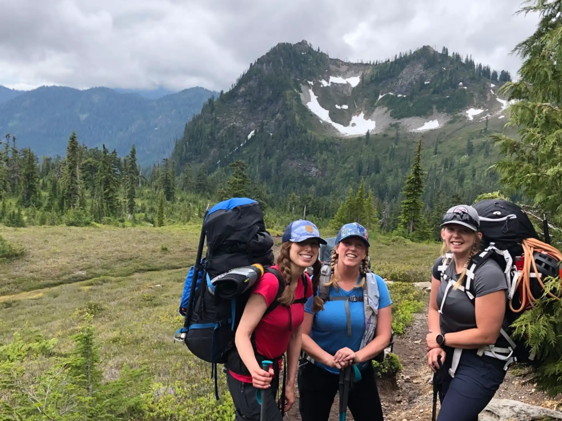a group of hikers posing for a photo in front of a mountain