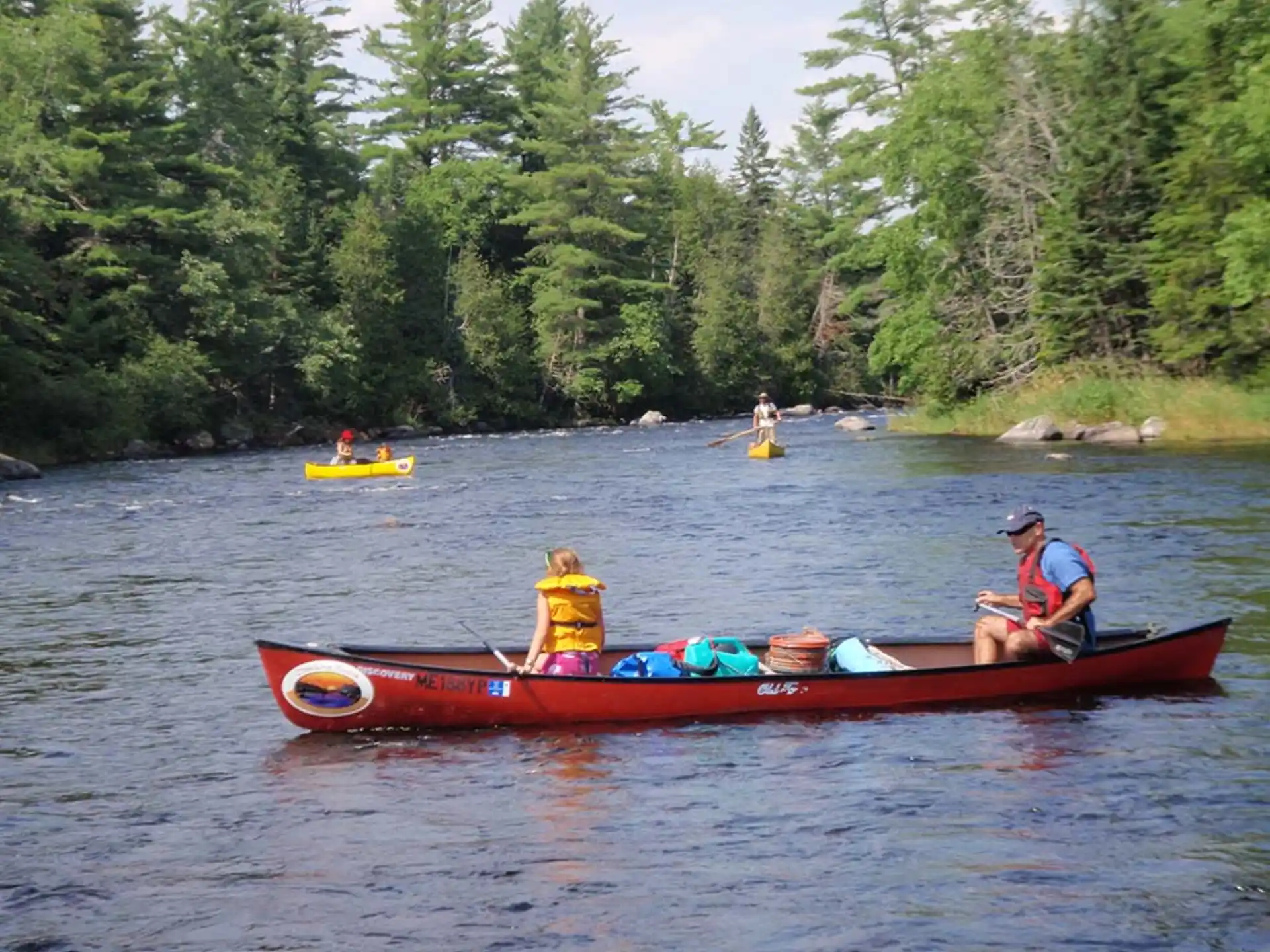 a group of people in canoes on a river