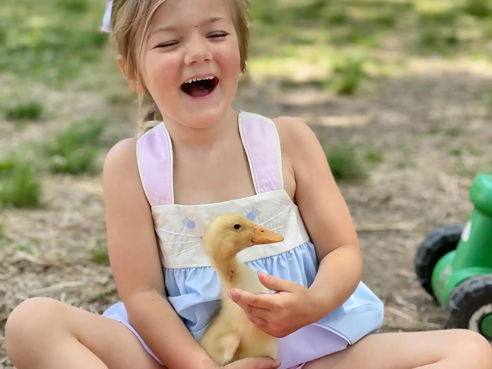 a girl sitting on a pink toy