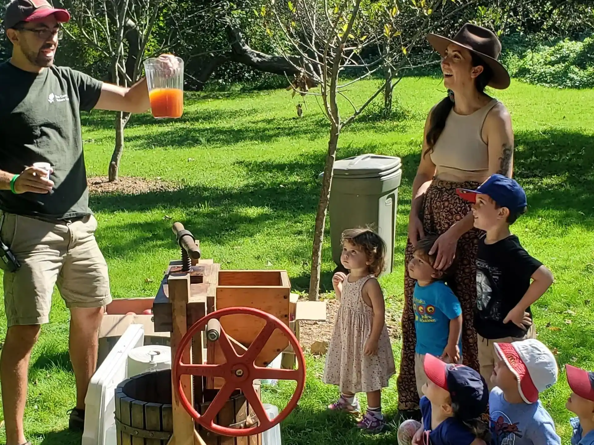 a group of people stand around a barrel