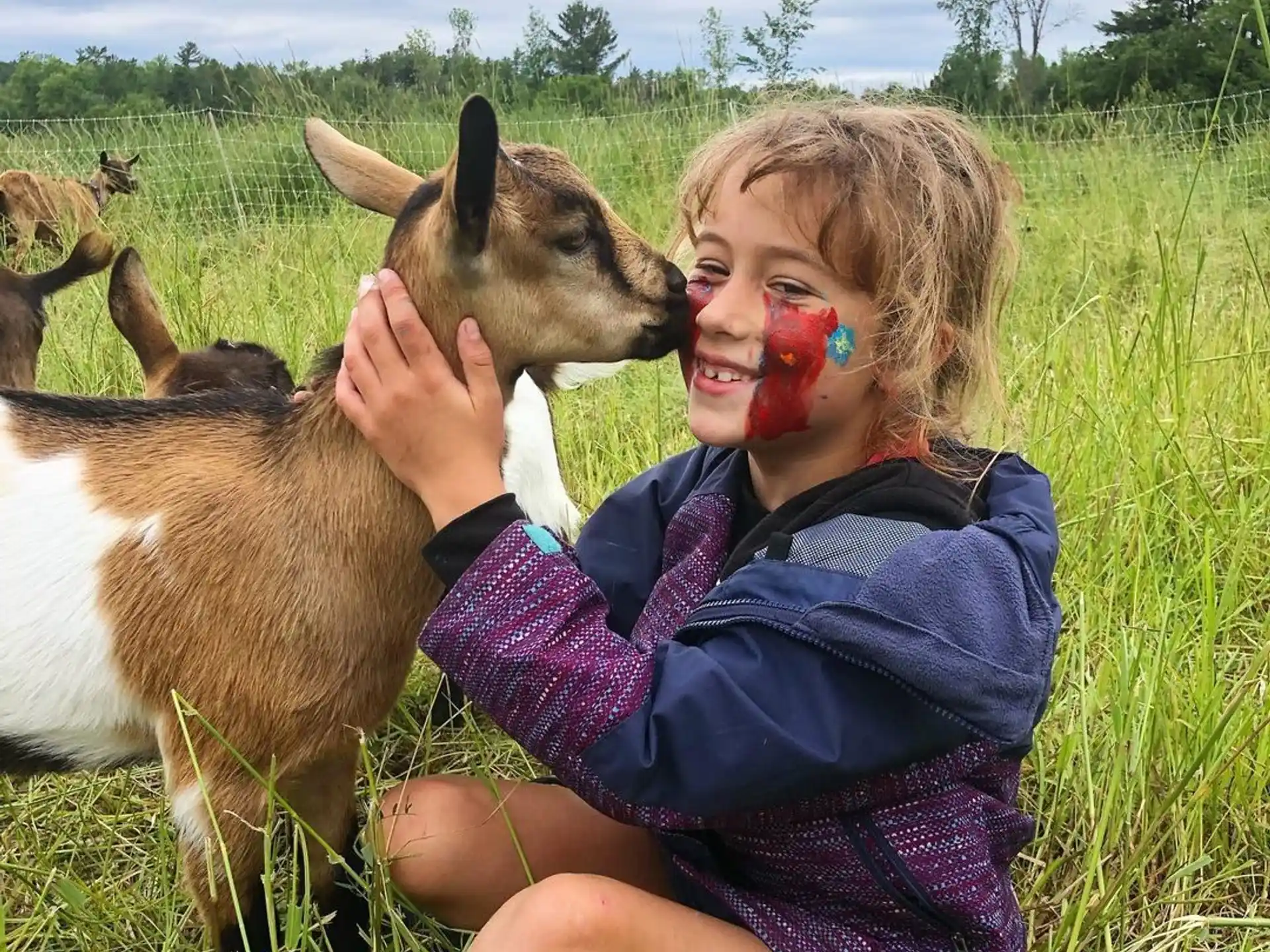 a girl with a deer licking her face