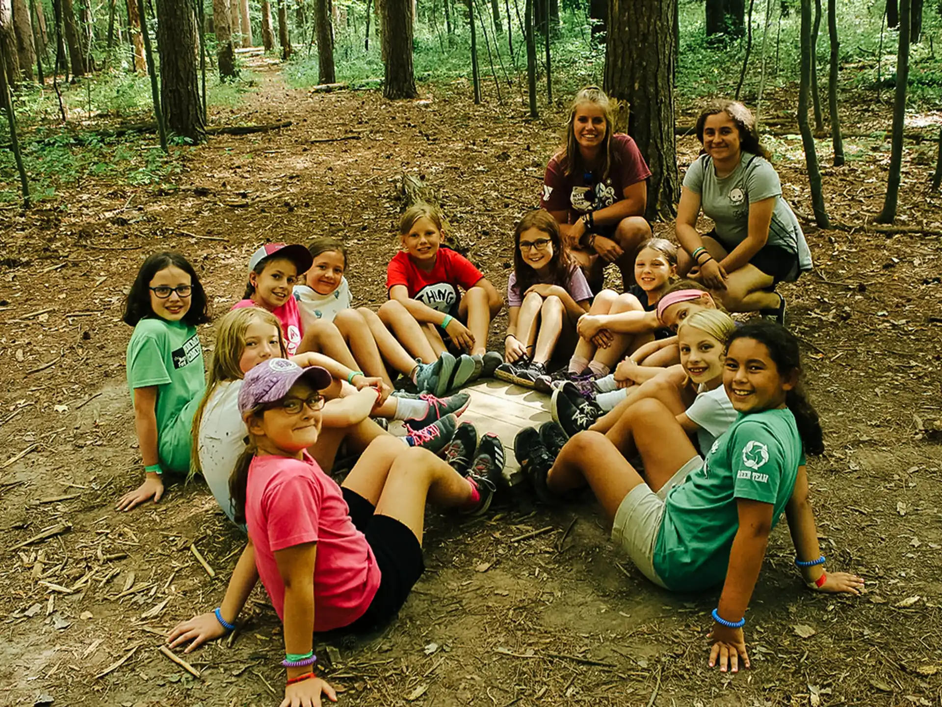 a group of people sitting on the ground posing for the camera
