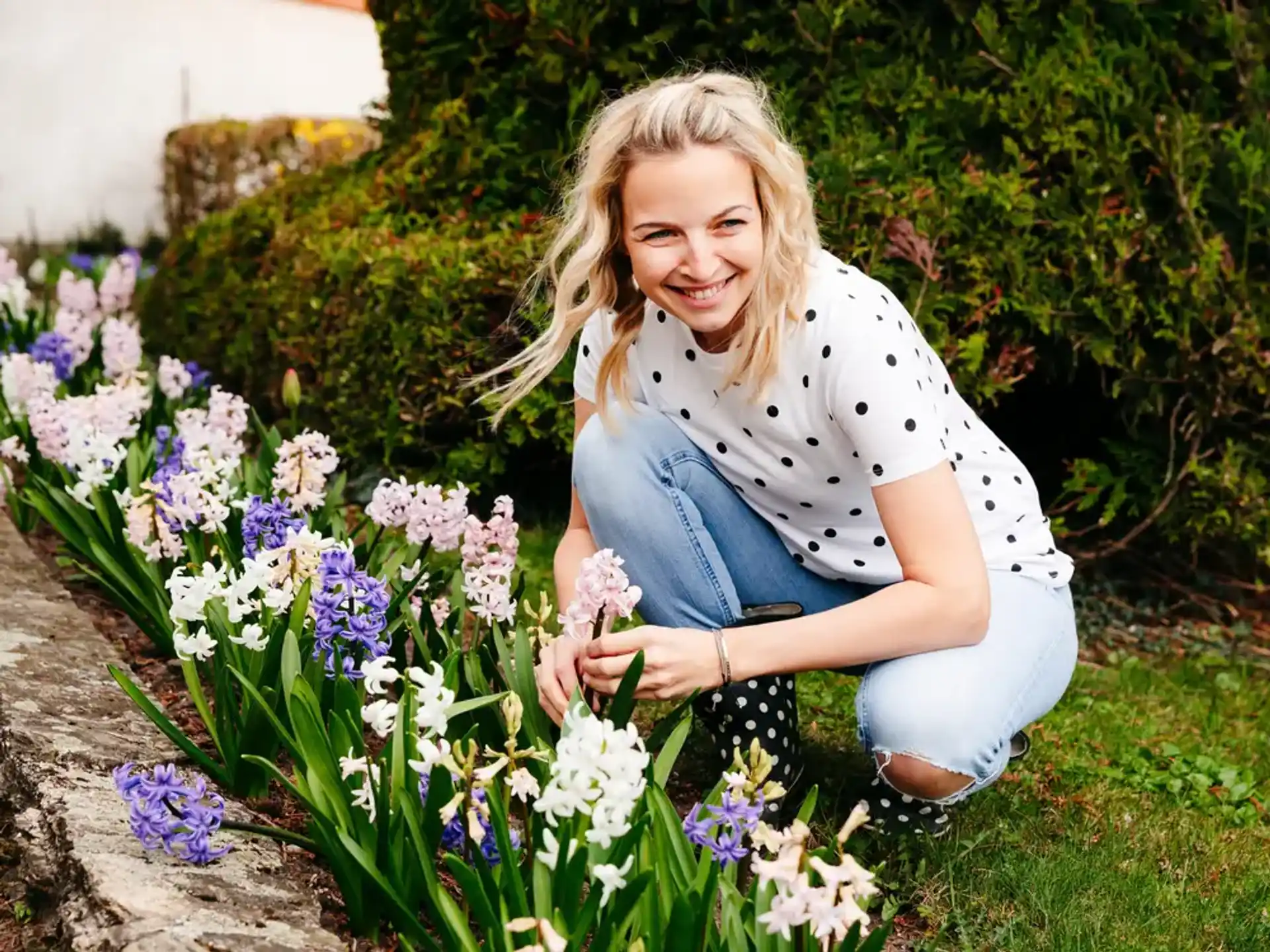 a person kneeling in a field of flowers