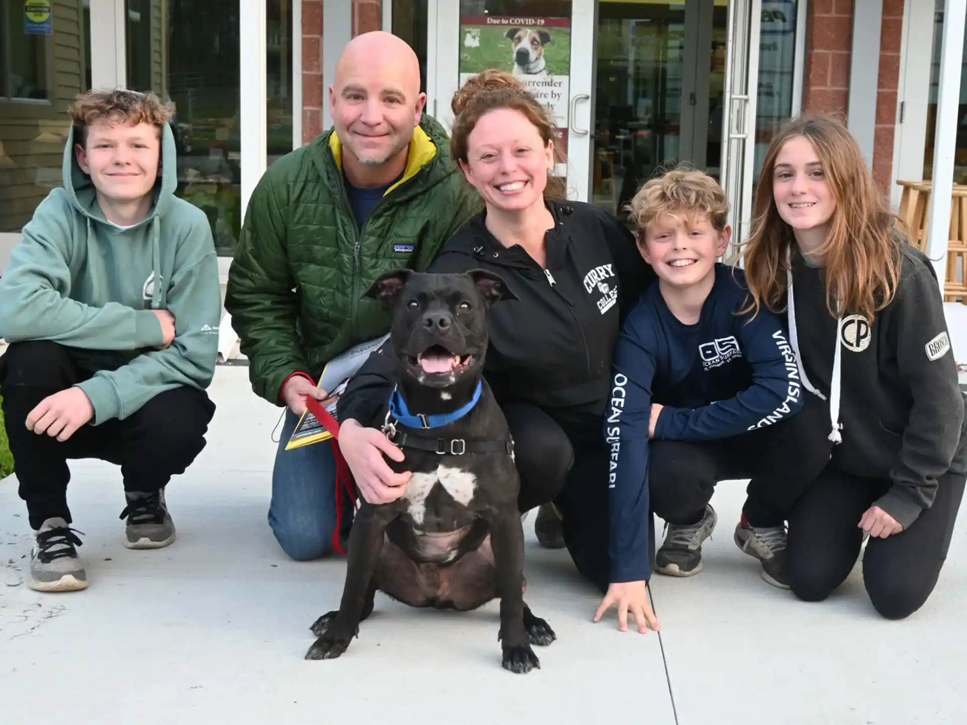 a group of people posing with a dog