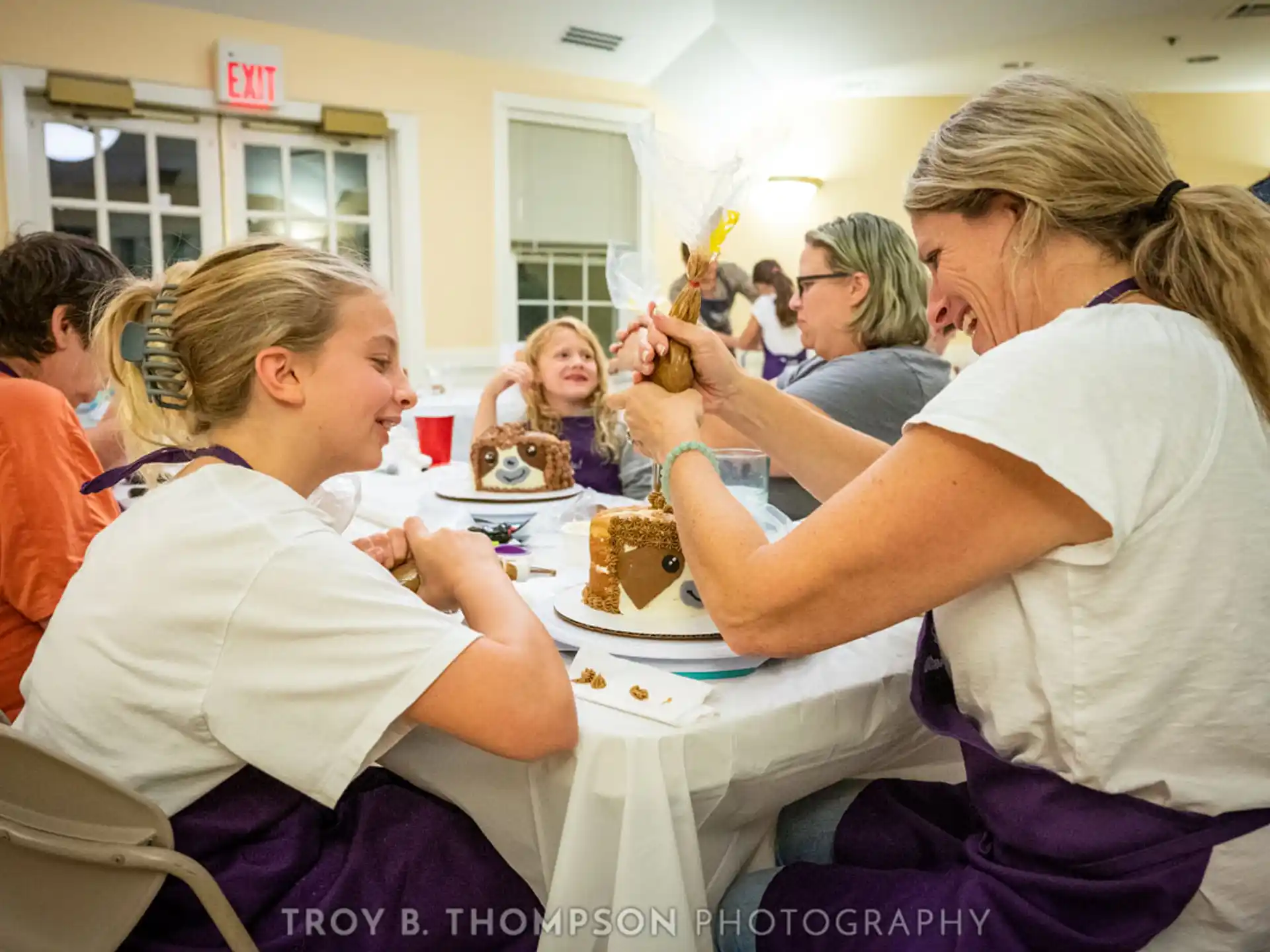 a group of people sitting at a table eating cake