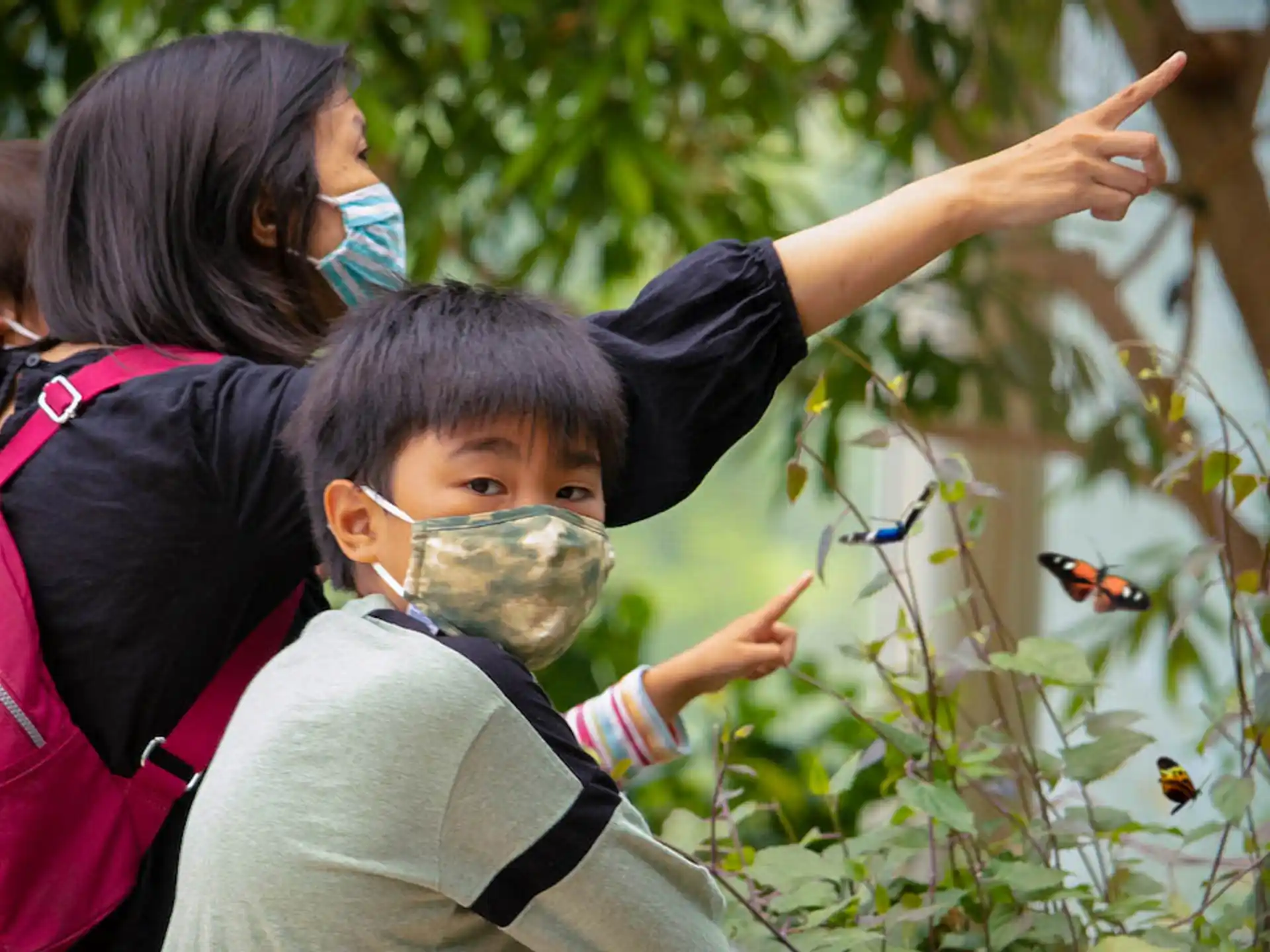 a group of people looking at a boy with a face mask