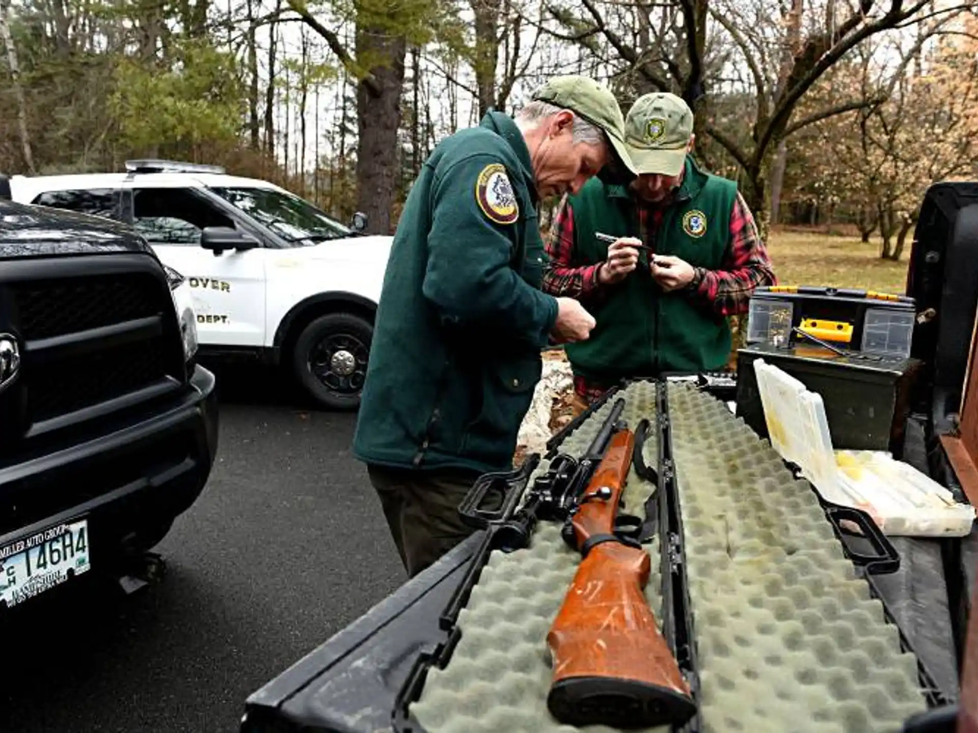 a couple of men in uniform looking at a gun