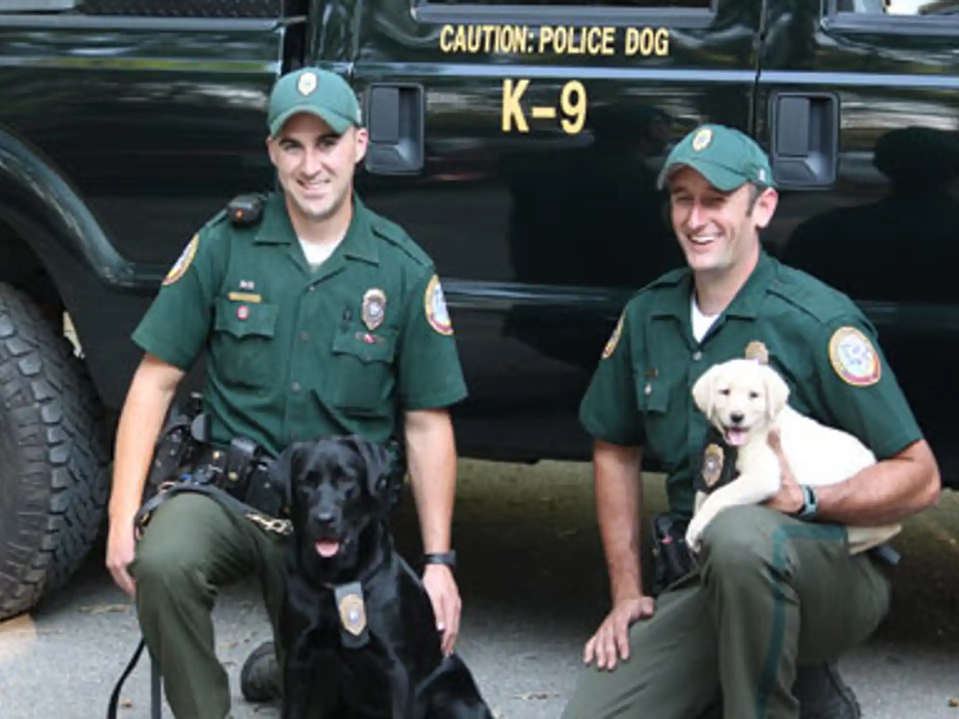 two men in uniform with a dog