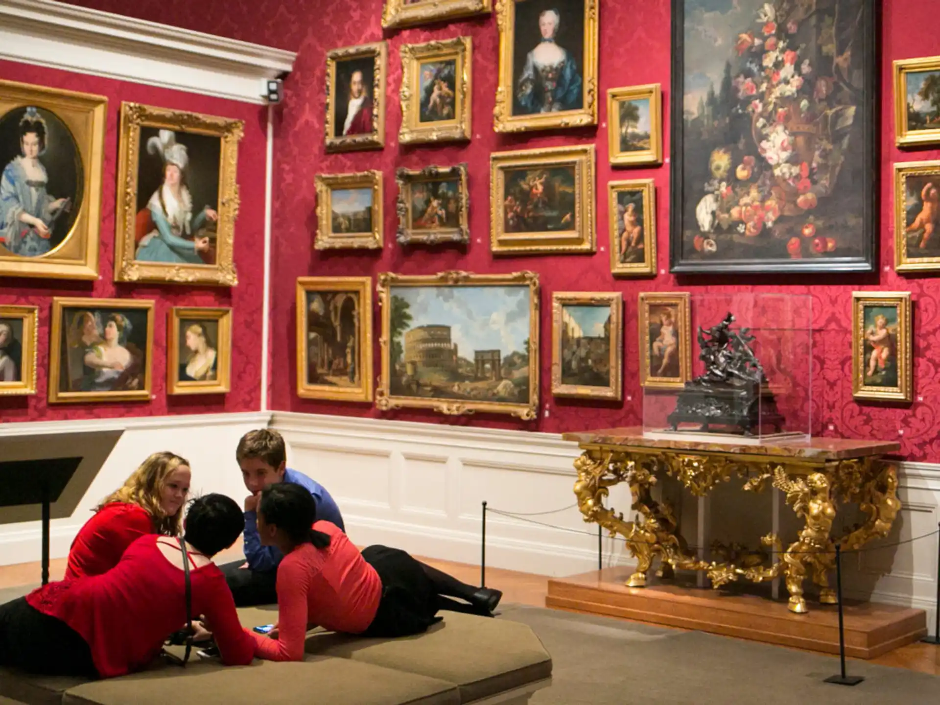 a group of people sitting on a couch in a room with art on the walls