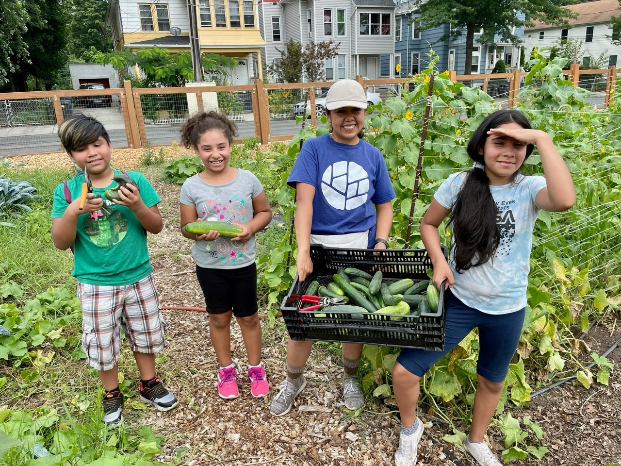 a group of kids holding a basket of vegetables