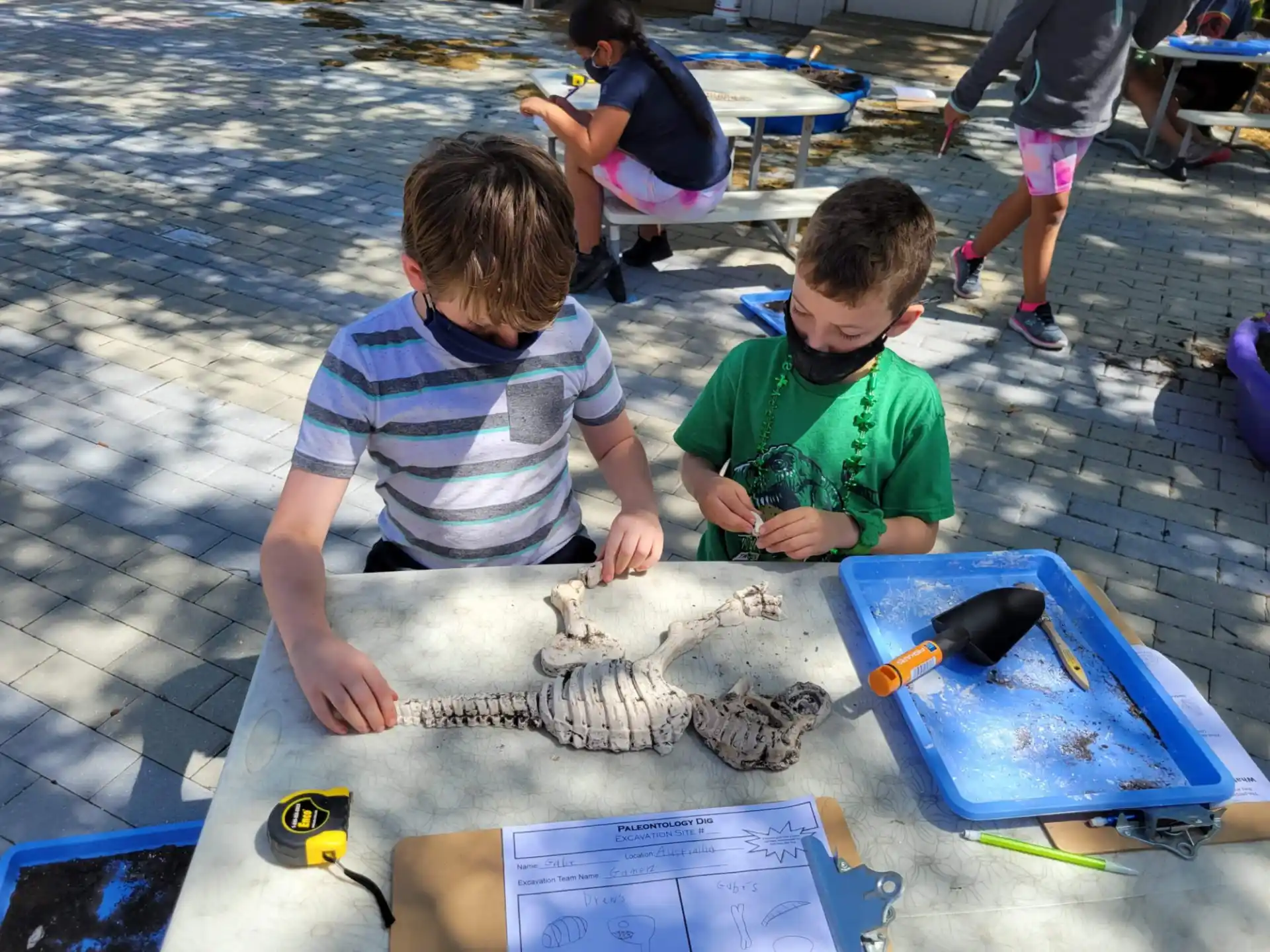 a couple of boys sitting at a table with a fish