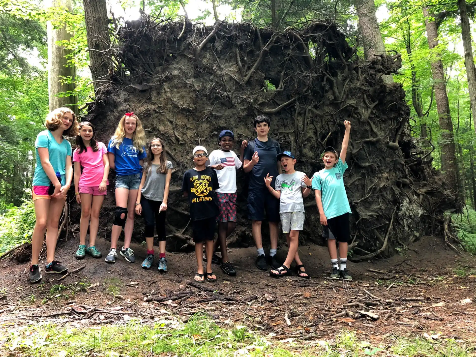 a group of people posing for a photo in front of a tree