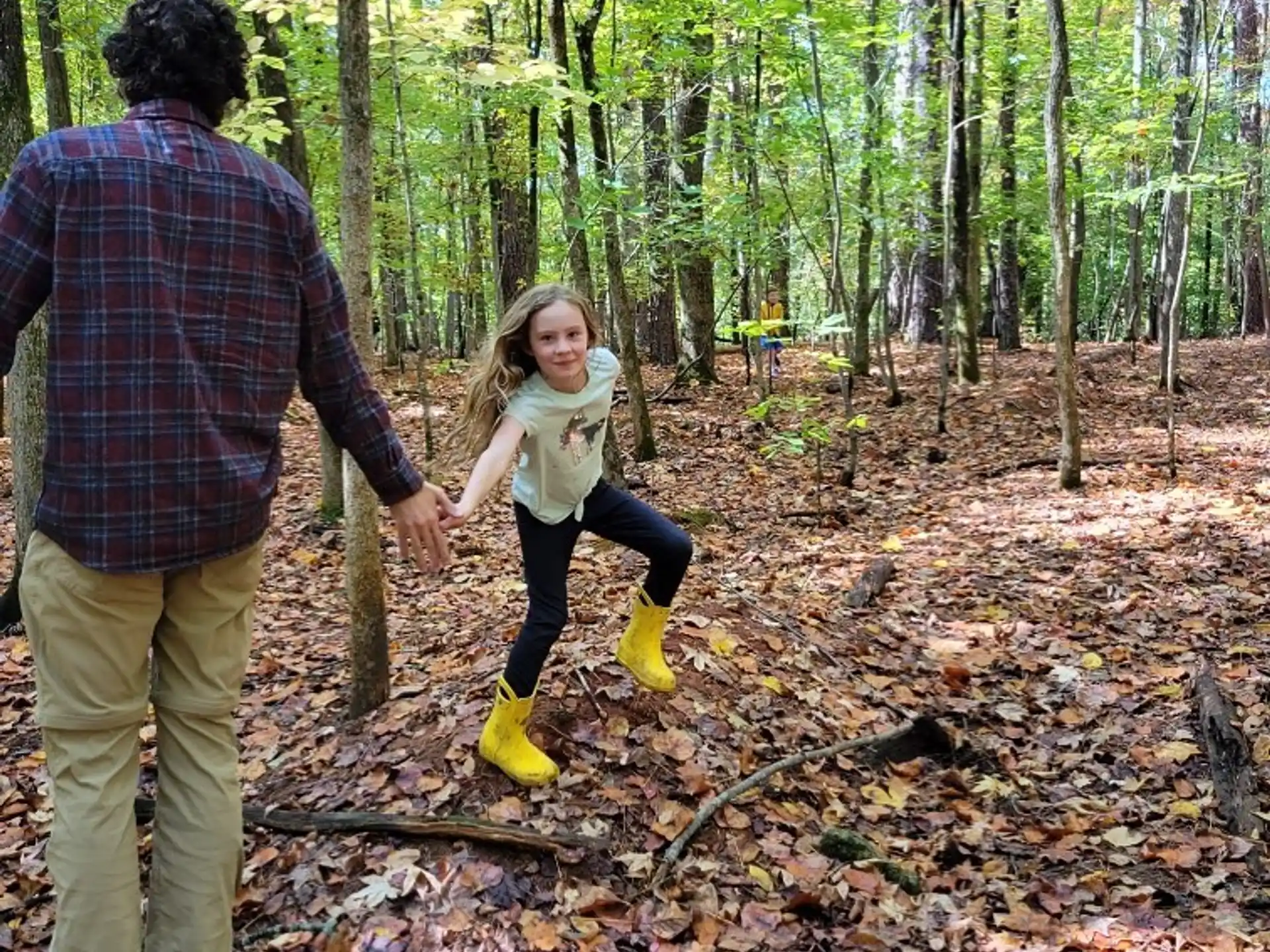 a man and a woman walking in the woods