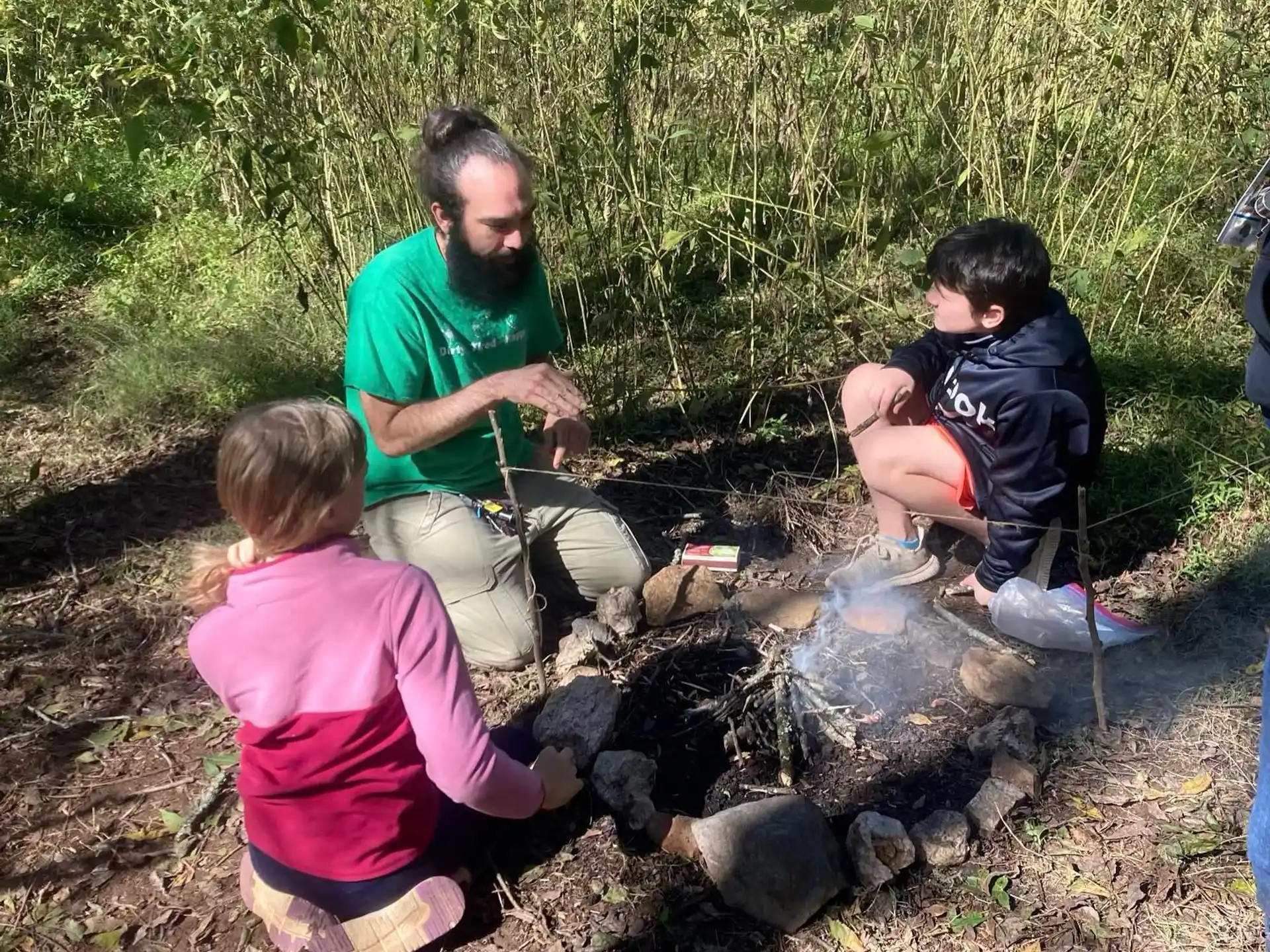 a person and two children sitting on a fire pit