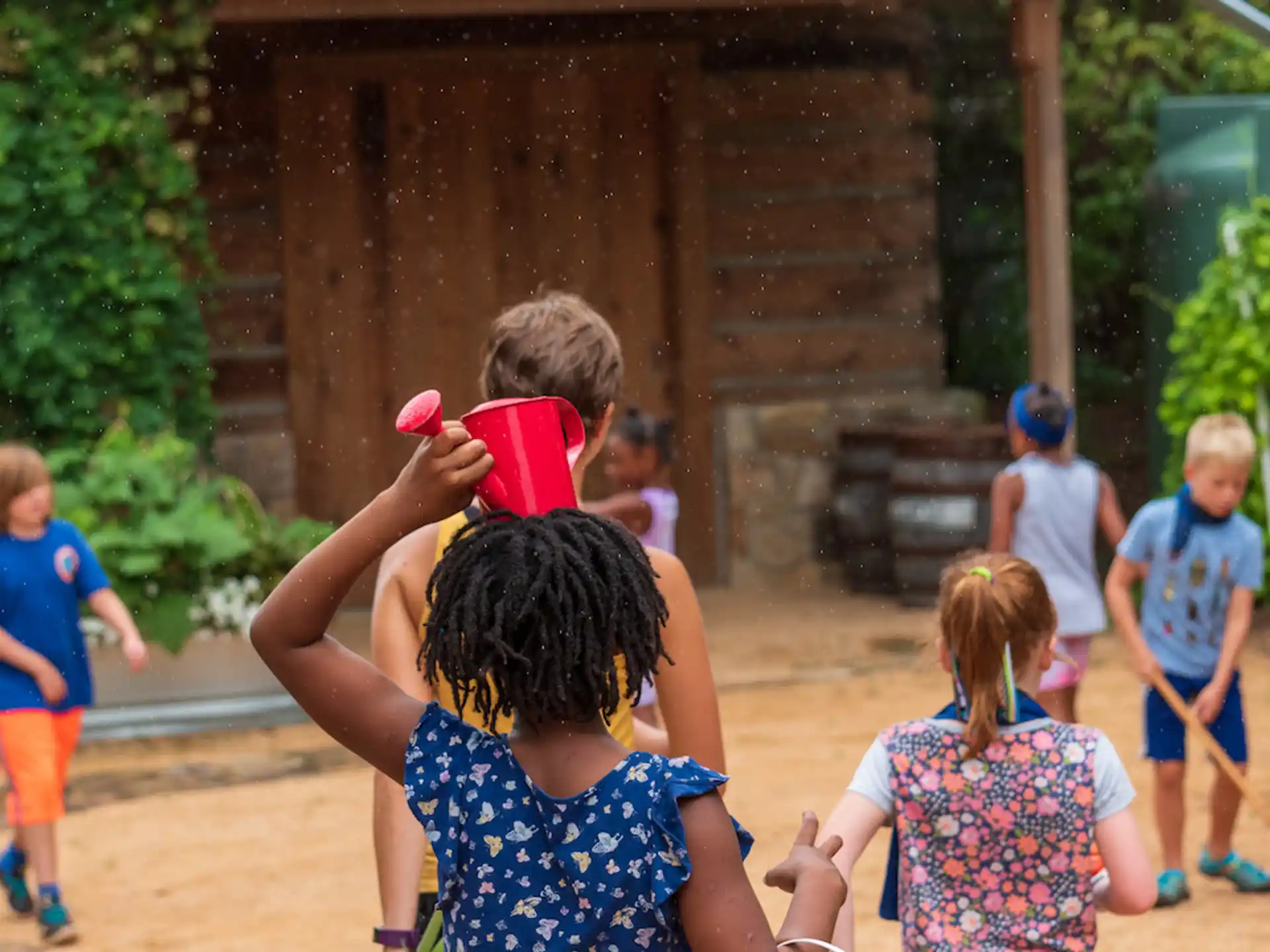 a group of children playing with a red cup