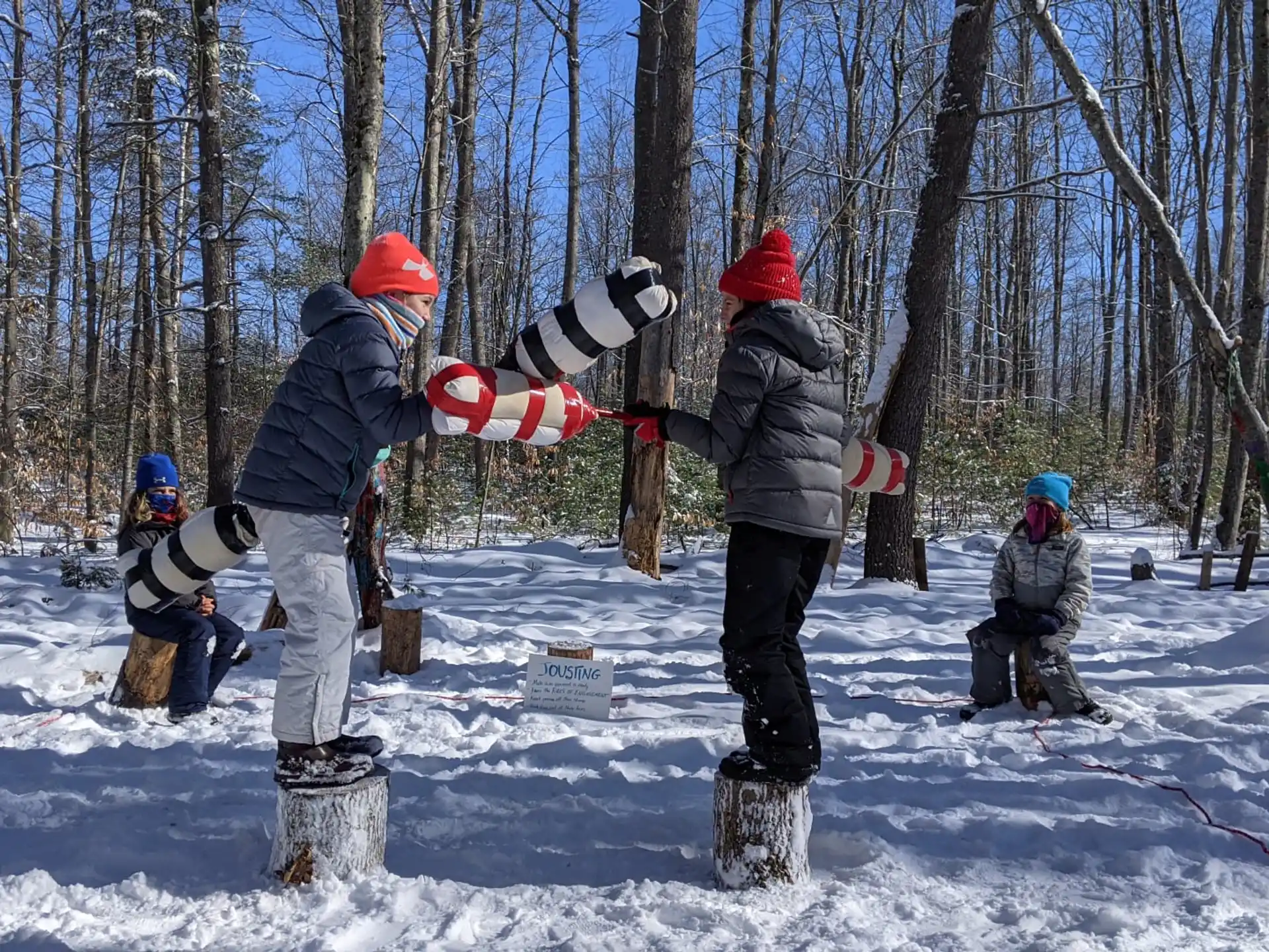 a group of people stand around a snowboard