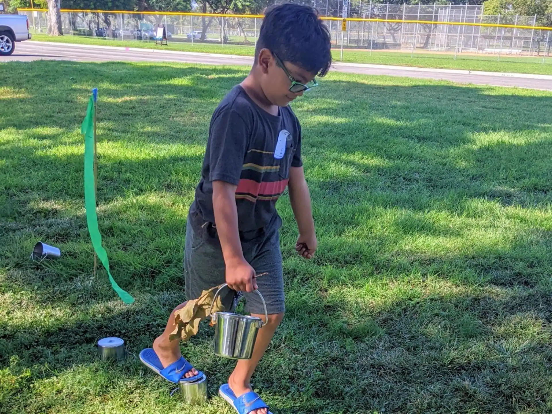 a man holding a bucket and a bucket in a grass field