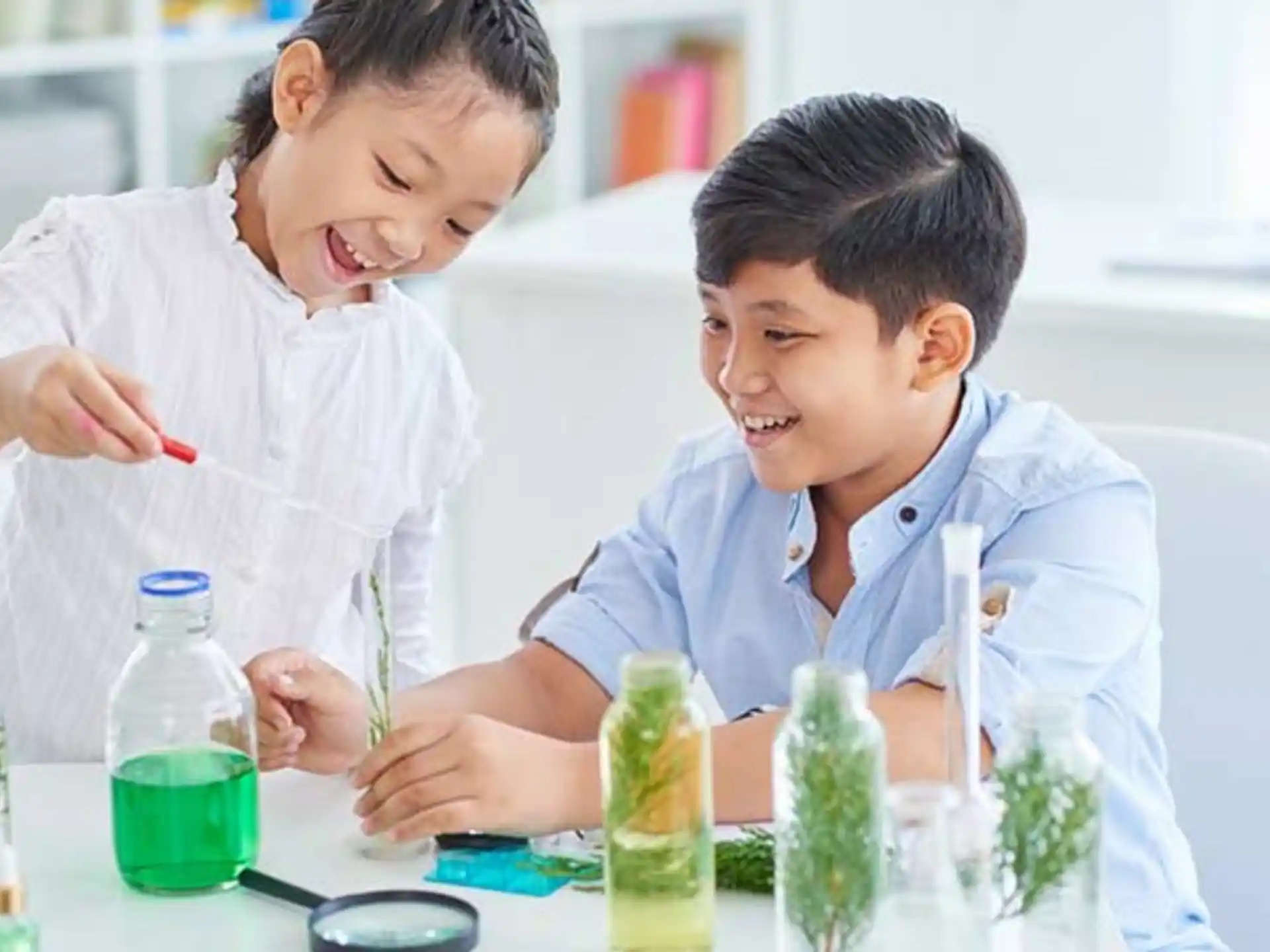 a couple of young boys looking at a test tube